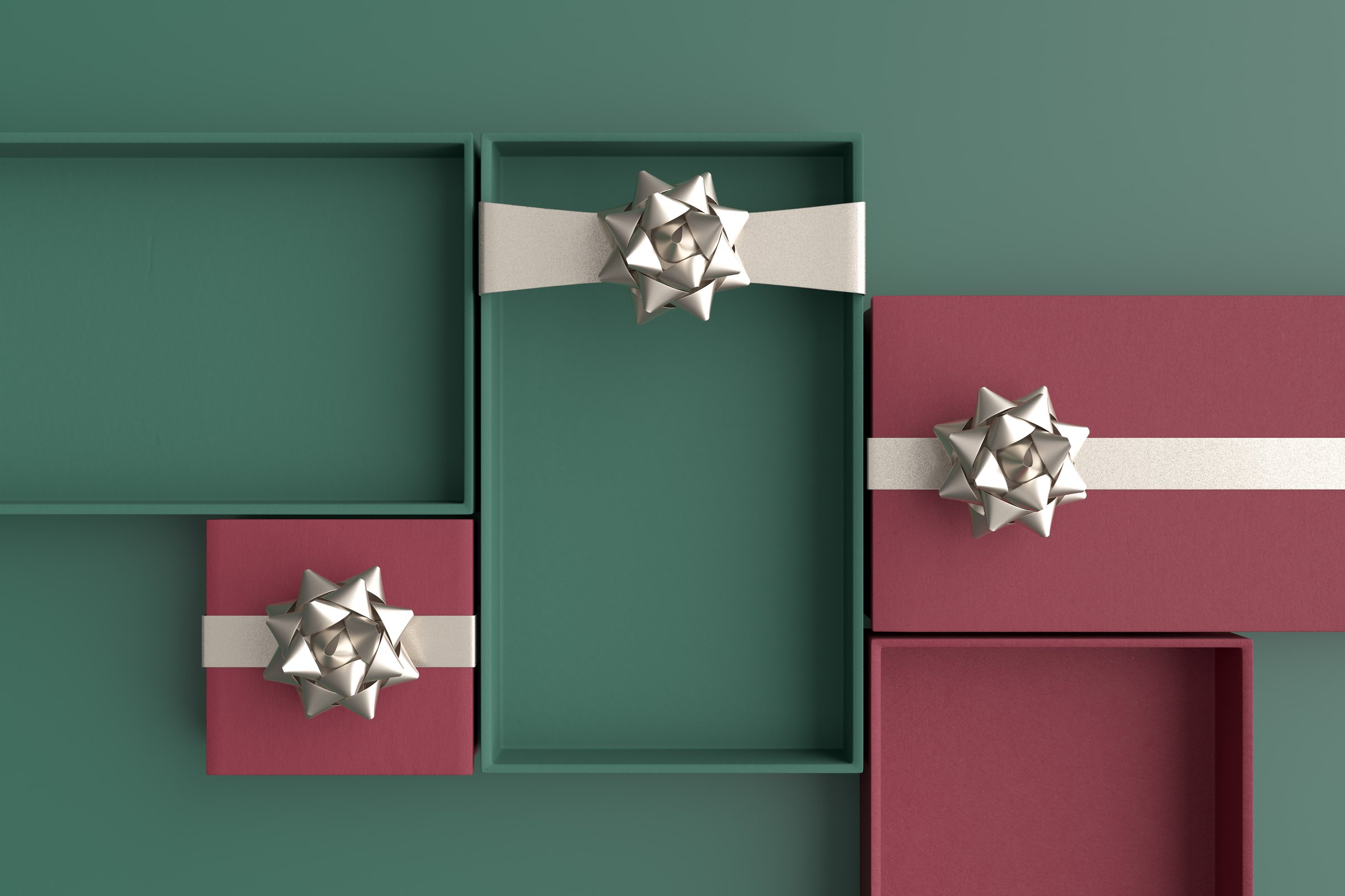 Open gift boxes in green and maroon colors with silver bow and ribbon are lying on a green background, creating a festive atmosphere