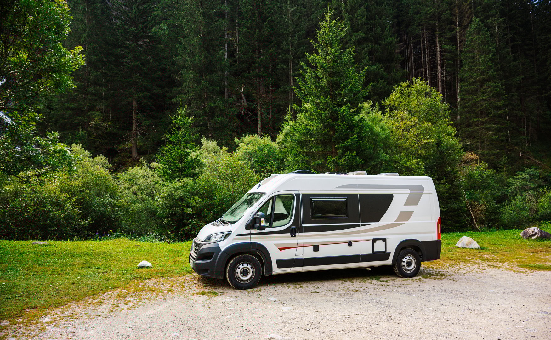 Campervan or motorhome parked in picnic resting area in front of amazing Staniskabach waterfalls (Schleierfall, Haslacherfall) in Kals am Grossglockner, Austria