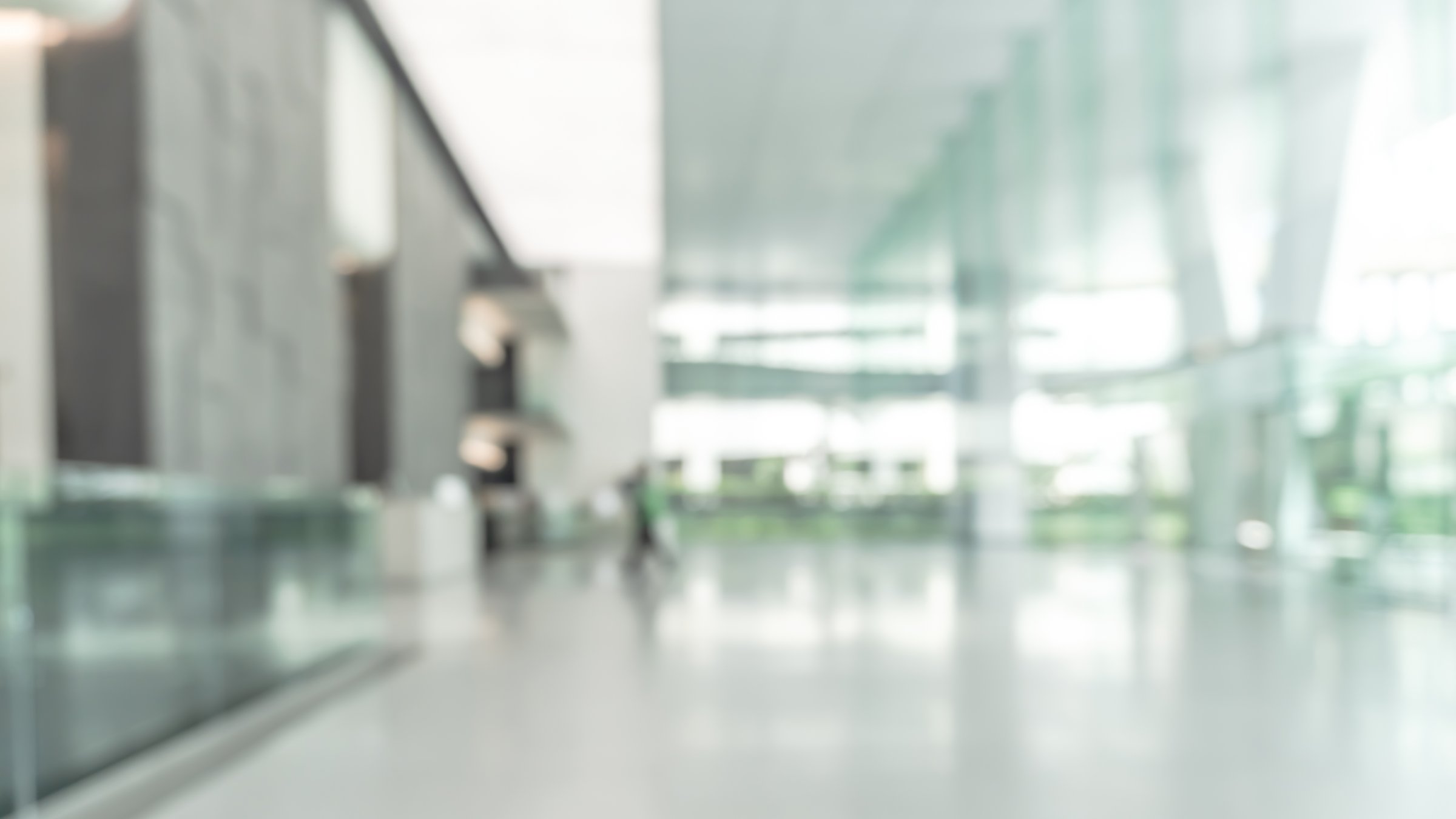 Blurred business office building lobby or hotel blur background interior view toward reception hall, modern luxury lounge, white room space with blurry corridor and glass wall