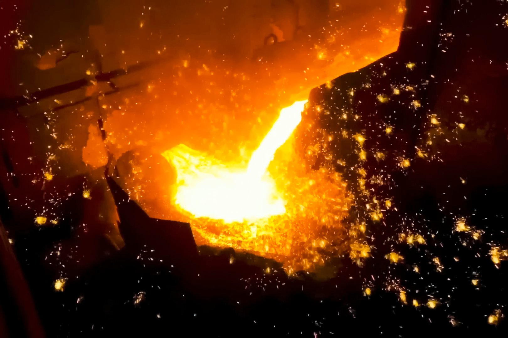 Ladle with molten iron pouring steel, blast furnace workshop.