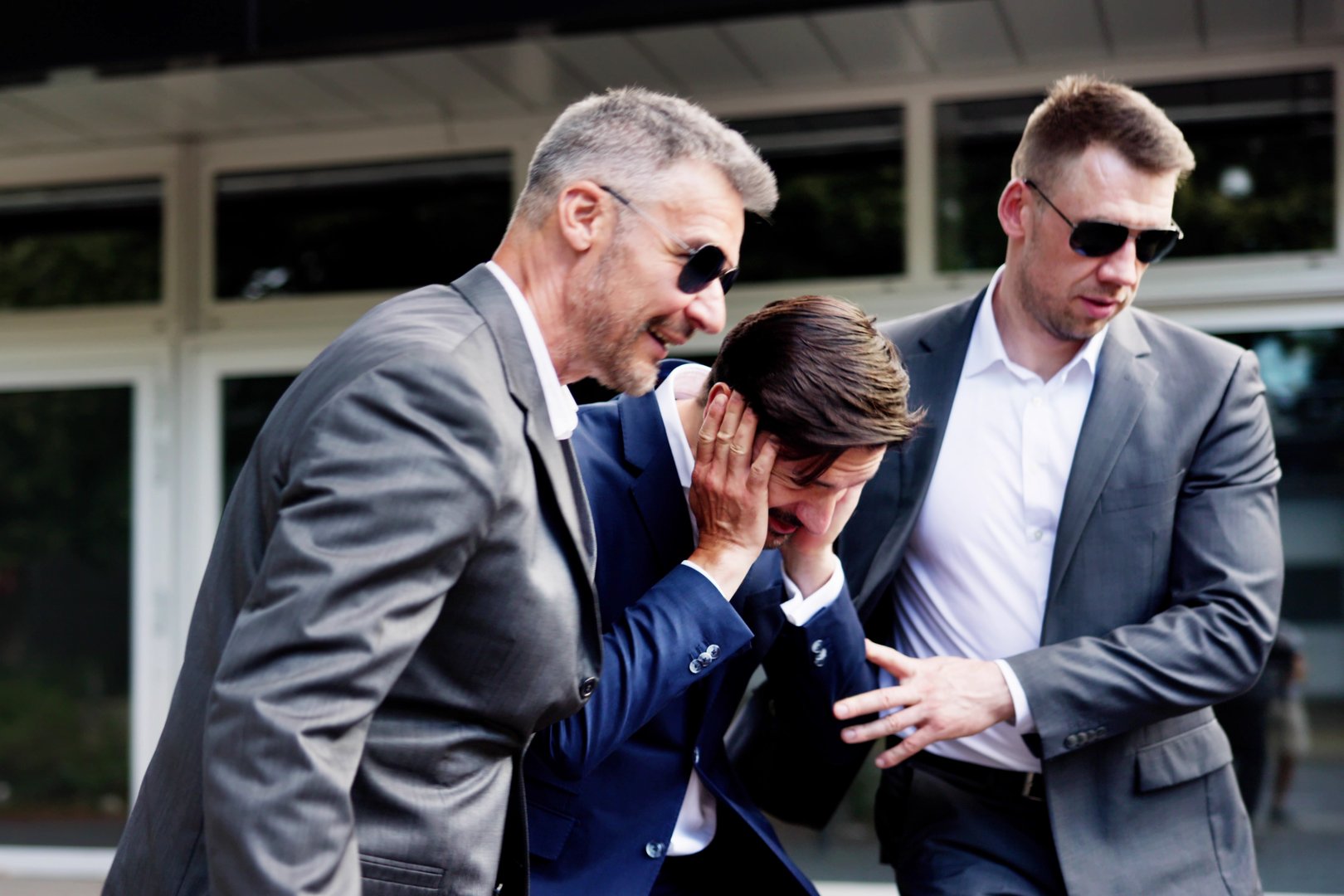 Elite bodyguards protect businessman during evacuation, ensuring safety after explosion and firearm incident. Professional security services in action.