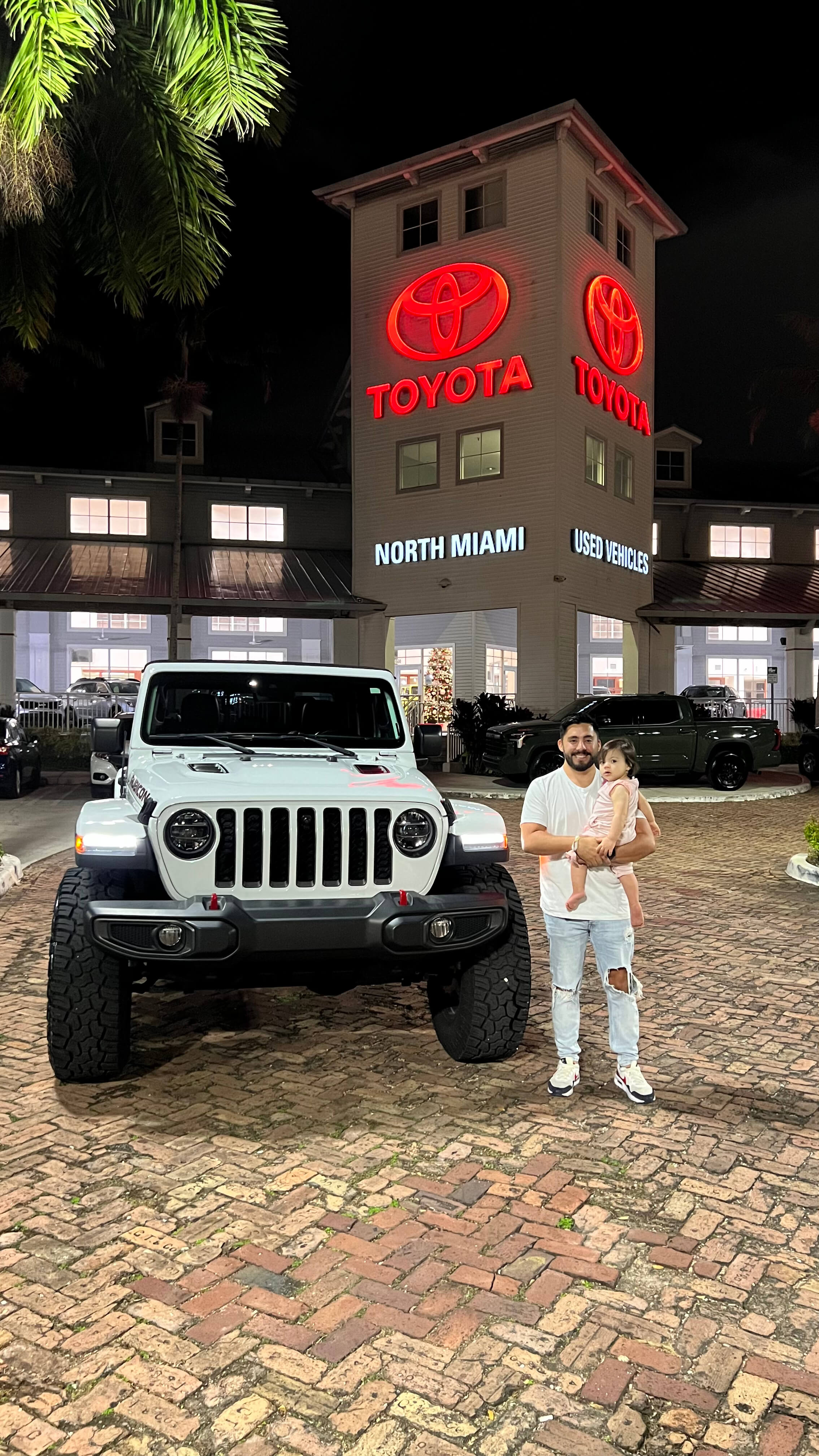 Cliente satisfecho junto a su vehículo recién adquirido