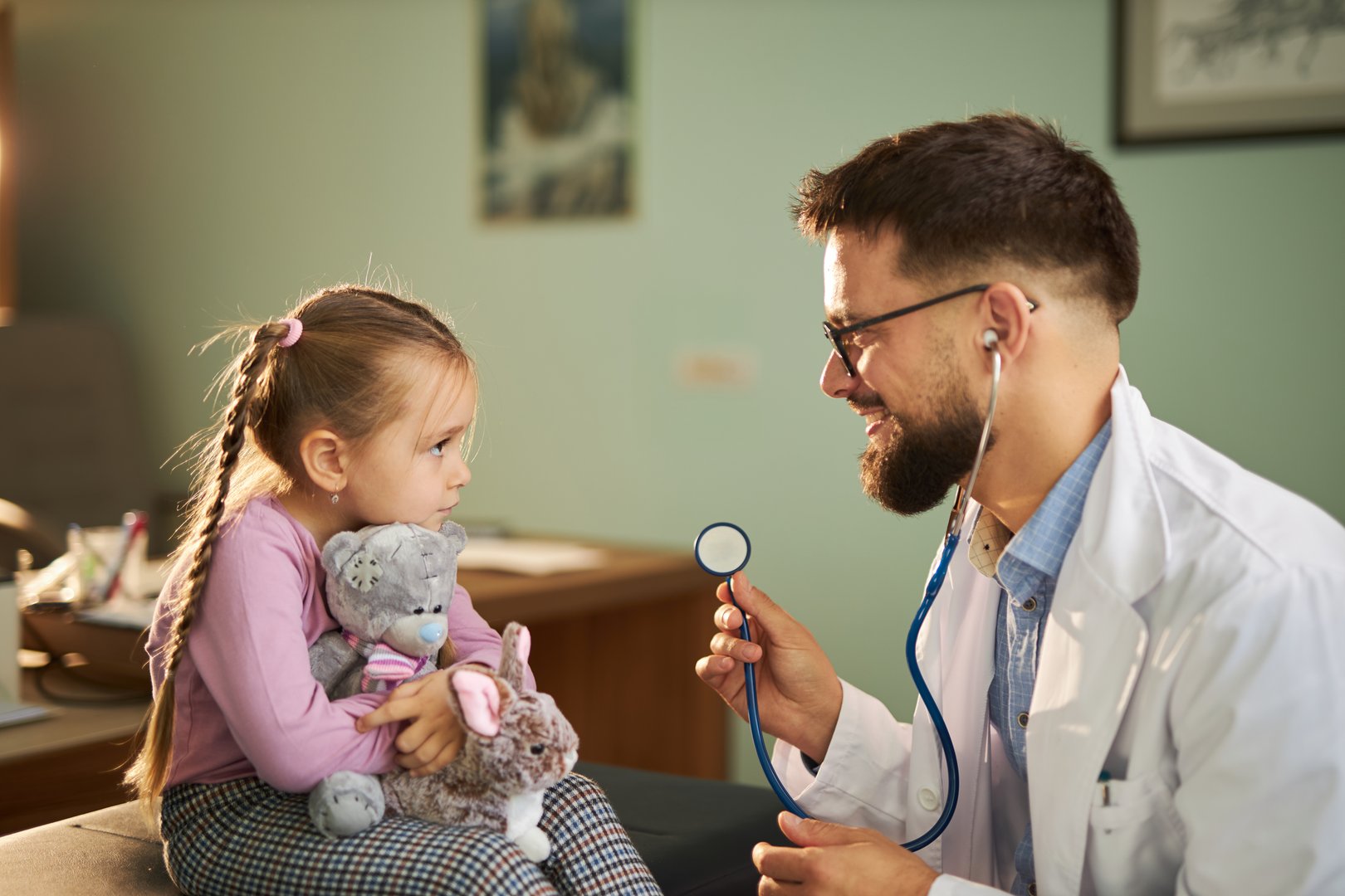 Cute girl talking to her pediatrician at doctor's office.