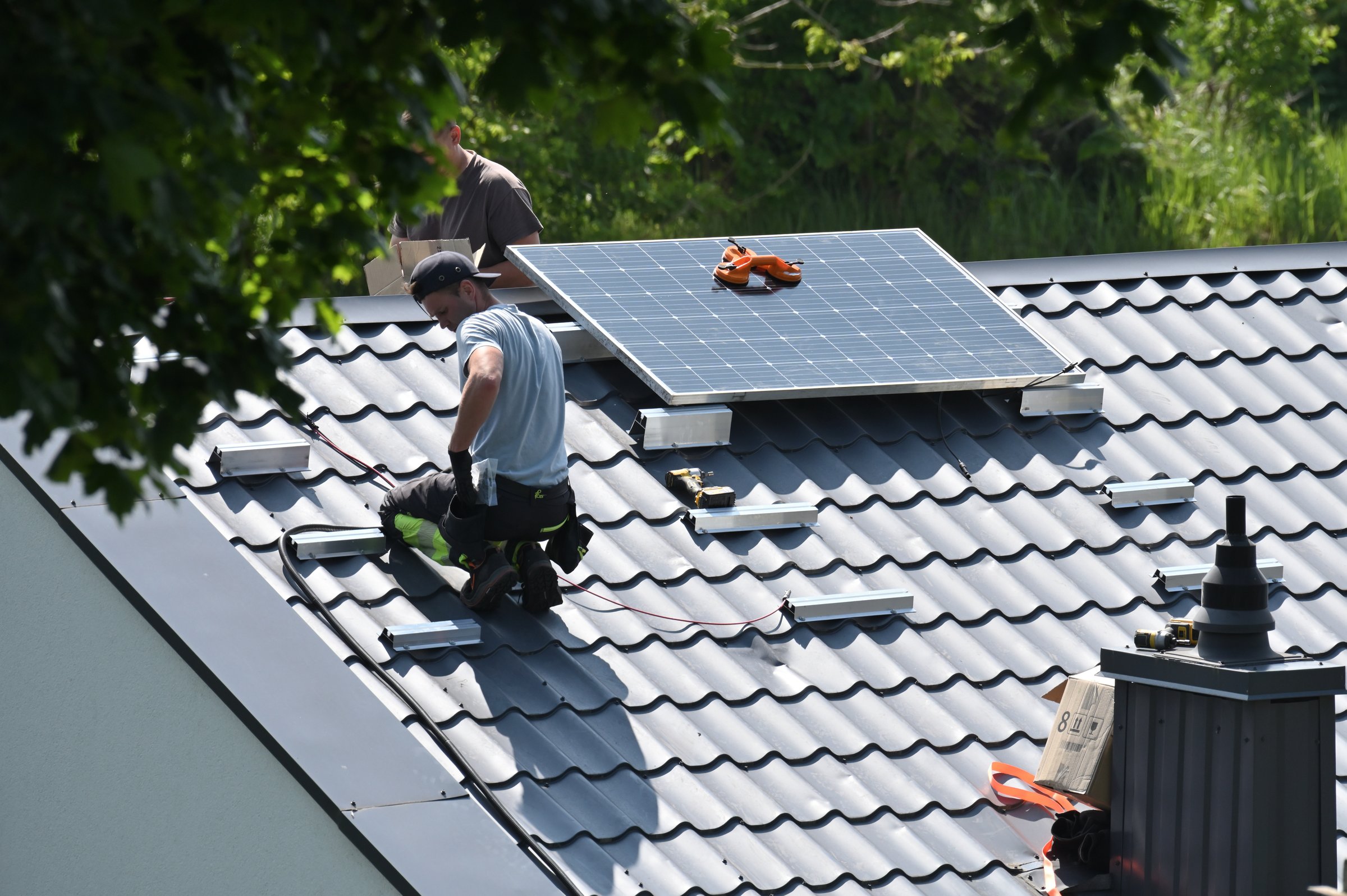 Vilnius, Lithuania - June 14, 2025: Unknown people installing solar panels on the roof in Vilnius, Lithuania.