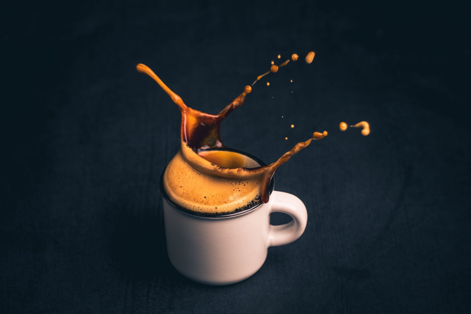 High Angle View Of Coffee In Cup Splashing On Table