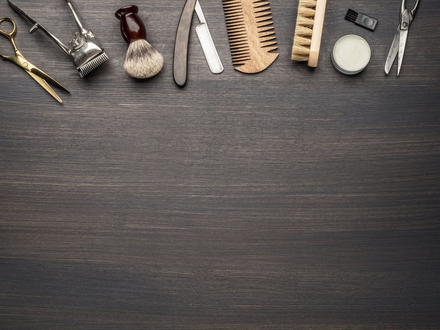 Classic grooming and hairdressing tools on wooden background. Top view on barbershop instruments  laying on dark wooden table.