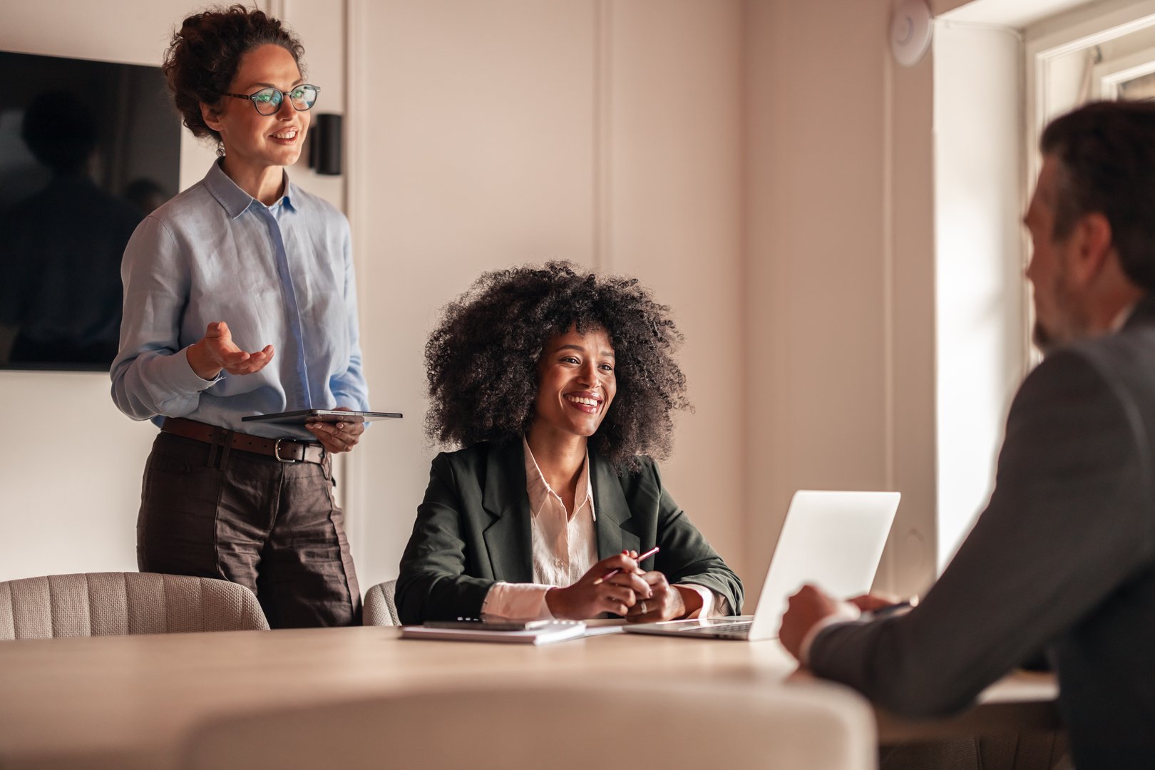 A group of professionals engaged in a collaborative business discussion in a modern office setting.