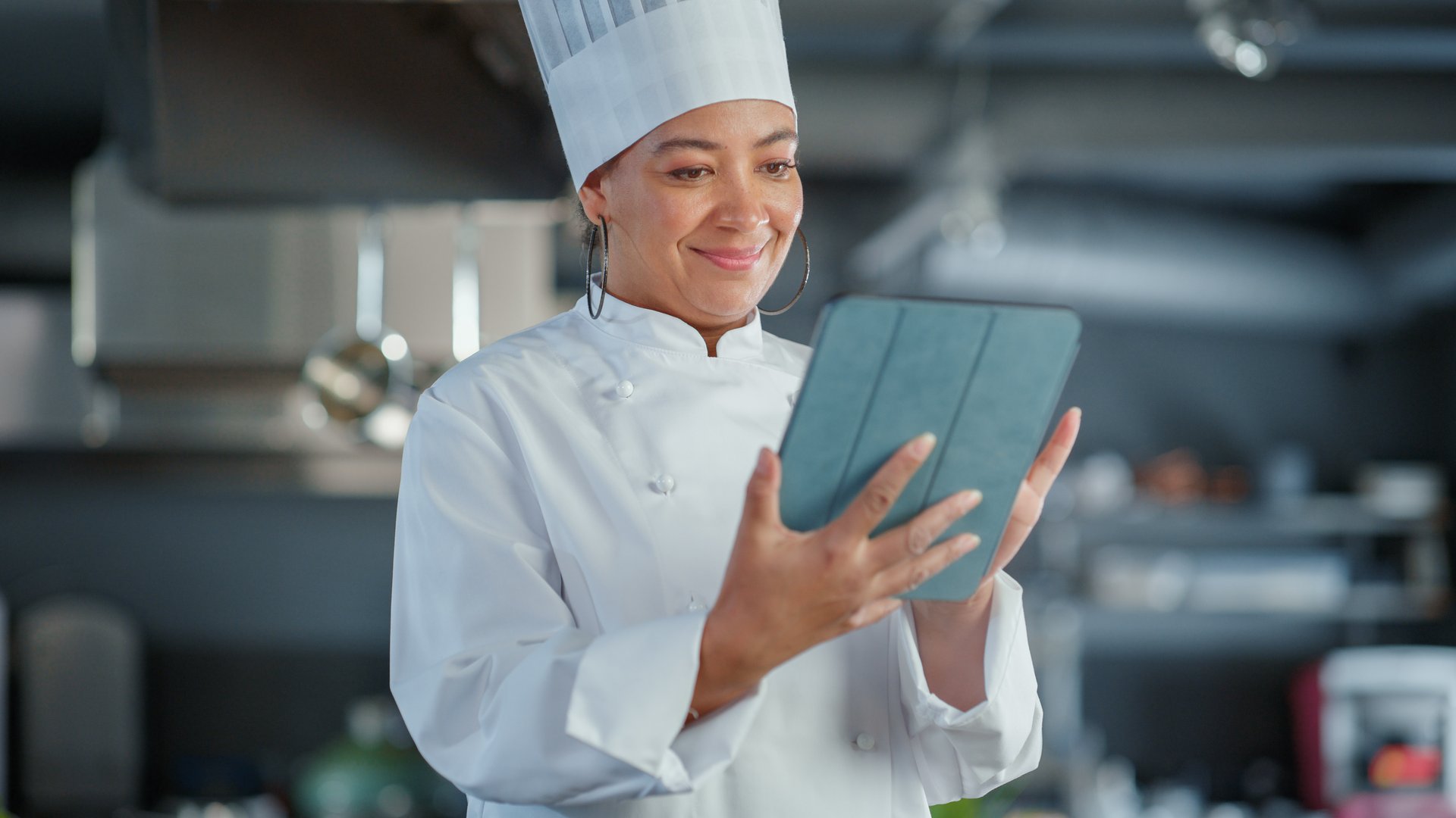 Restaurant Kitchen: Black Female Chef Cooking Delicious and Authentic Food, Uses Digital Tablet Computer. Professional Creates traditional Dish, using Healthy Ingredient, Prepare Meal Recipe. Medium