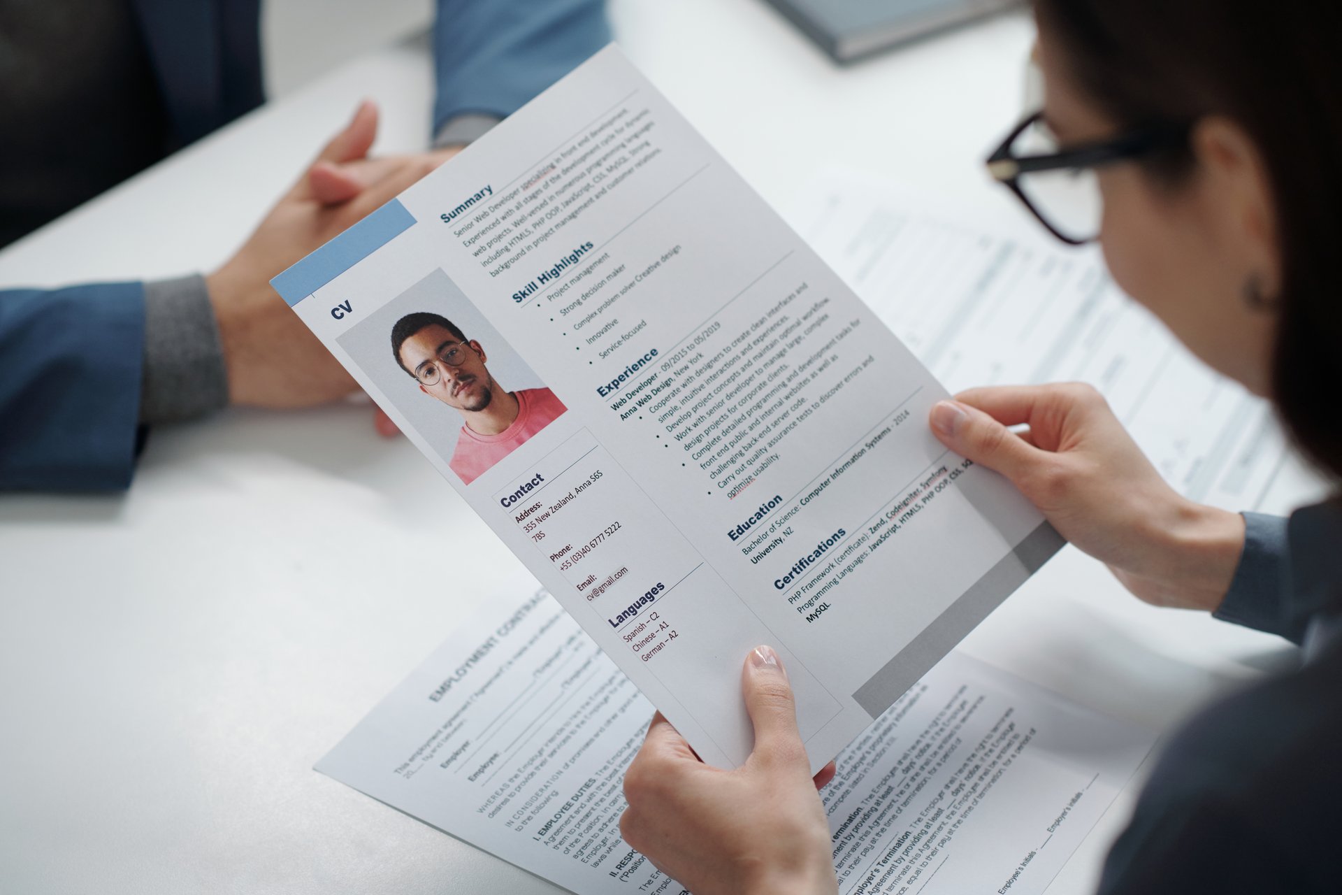 Top view close up of recruiter holding CV during job interview with candidate copy space