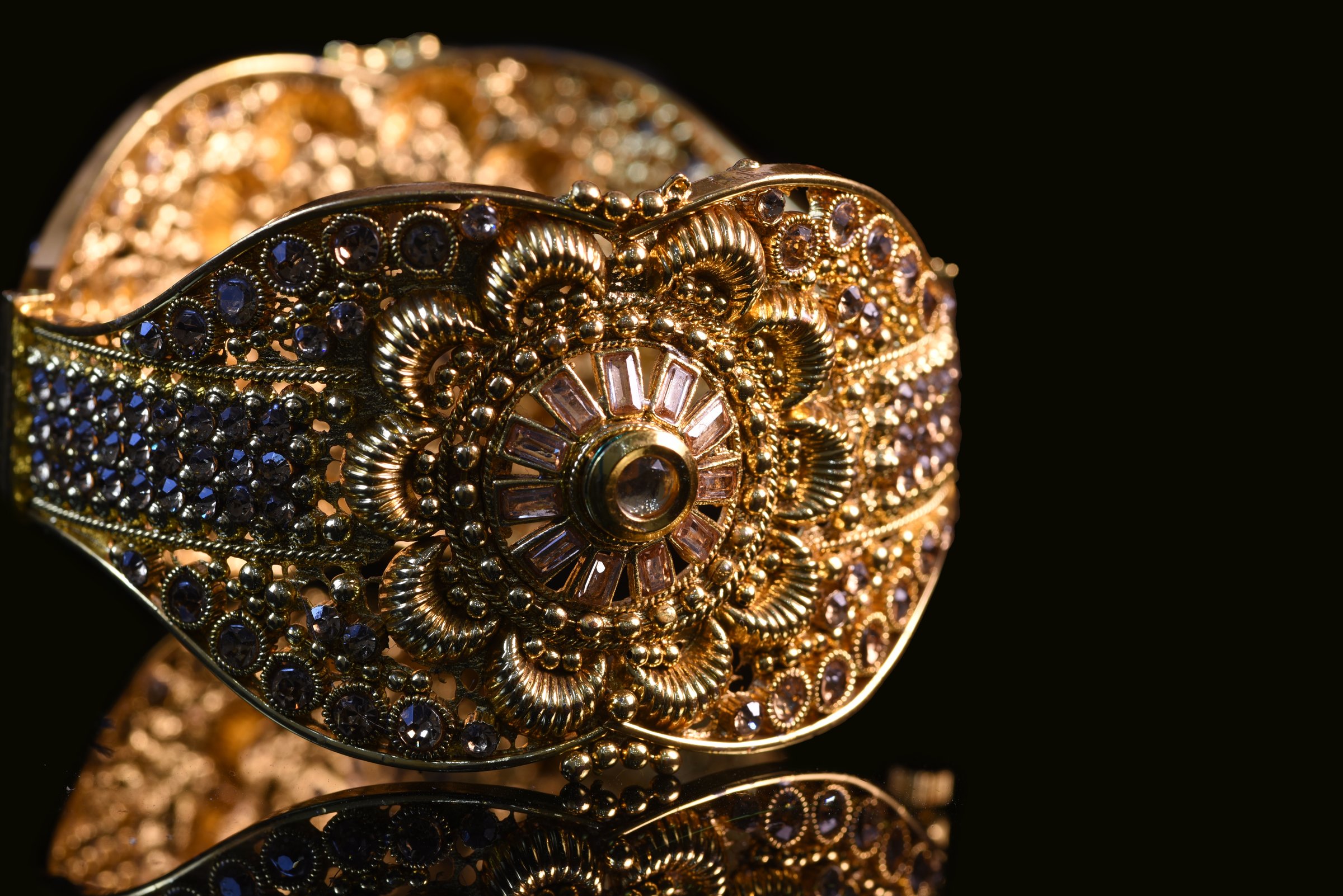 Pair of Fancy designer Golden bracelet for woman fashion/ Gold plated jewelry closeup image on black background