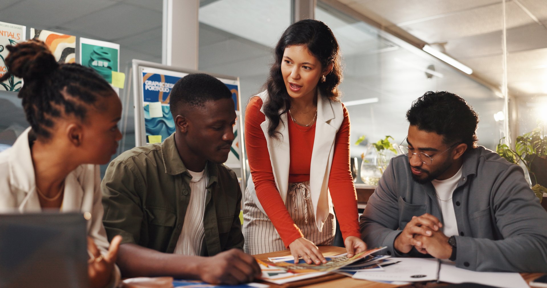 Creative, layout and woman with team in meeting for planning, collaboration and project ideas. Startup agency, office and workers with documents brainstorming for design process, feedback or strategy