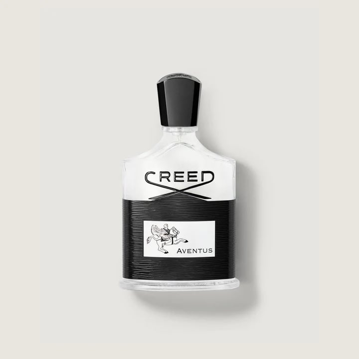 Creed Aventus fragrance bottle with black and silver design on a light background.