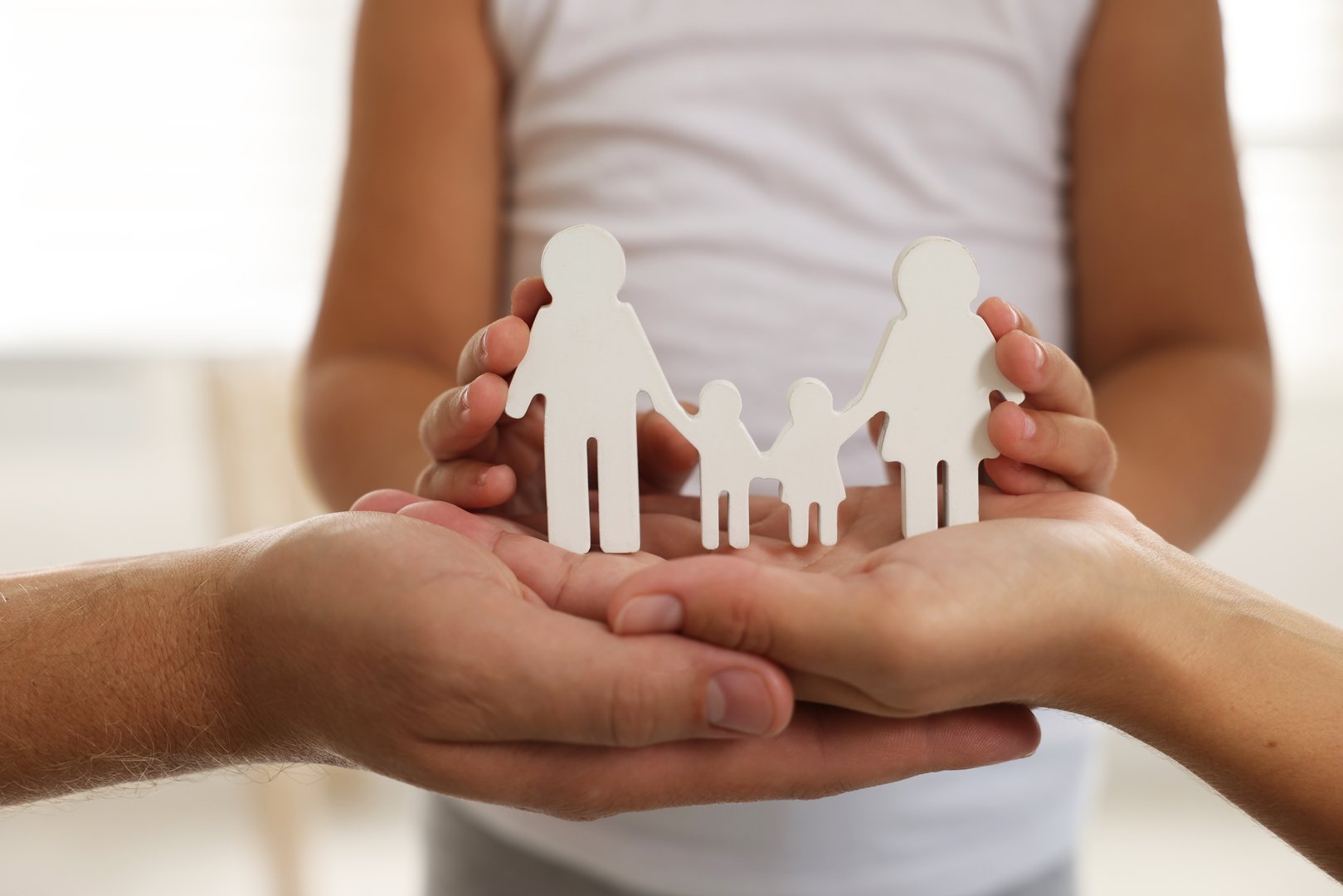 Parents and child with figures of family indoors, closeup