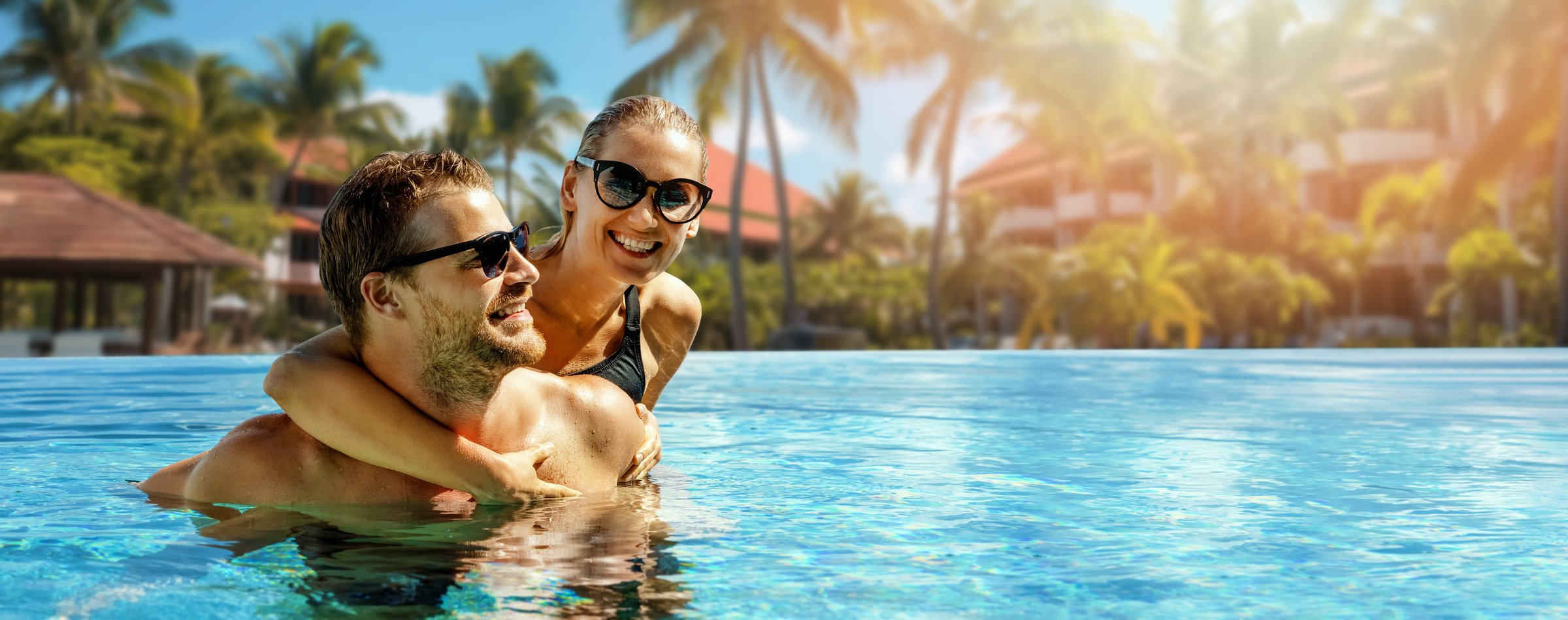 smiling happy couple having fun together in resort swimming pool. summer vacation, getaway travel. banner with copy space
