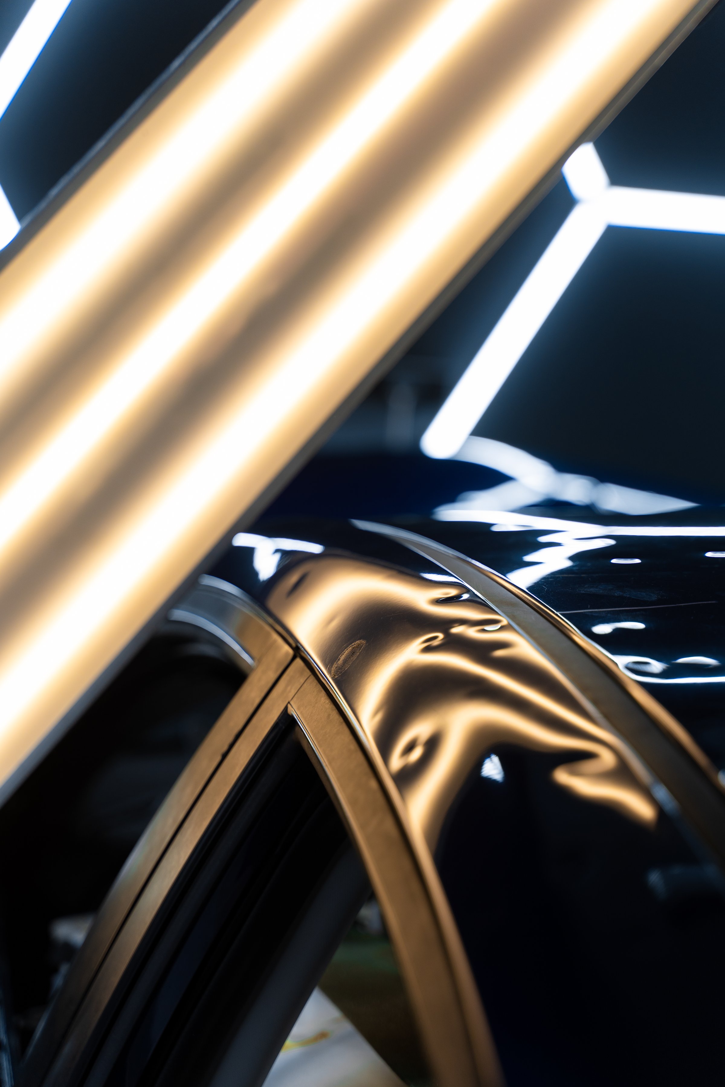 Car panel shows multiple dents under PDR lighting, used in paintless dent repair to expose imperfections. PDR lights reveal damage for accurate dent detection and assessment