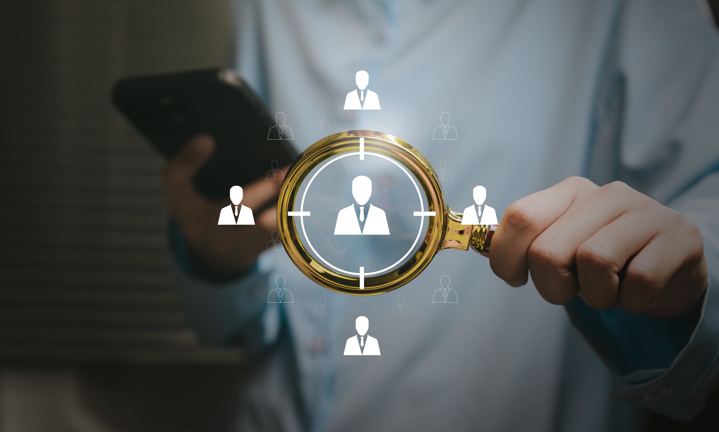 Targeting concept. Hand holding magnifying glass focusing on candidate icons, talent selection insight, workforce analytics, HR strategy, recruitment efficiency, decision management.