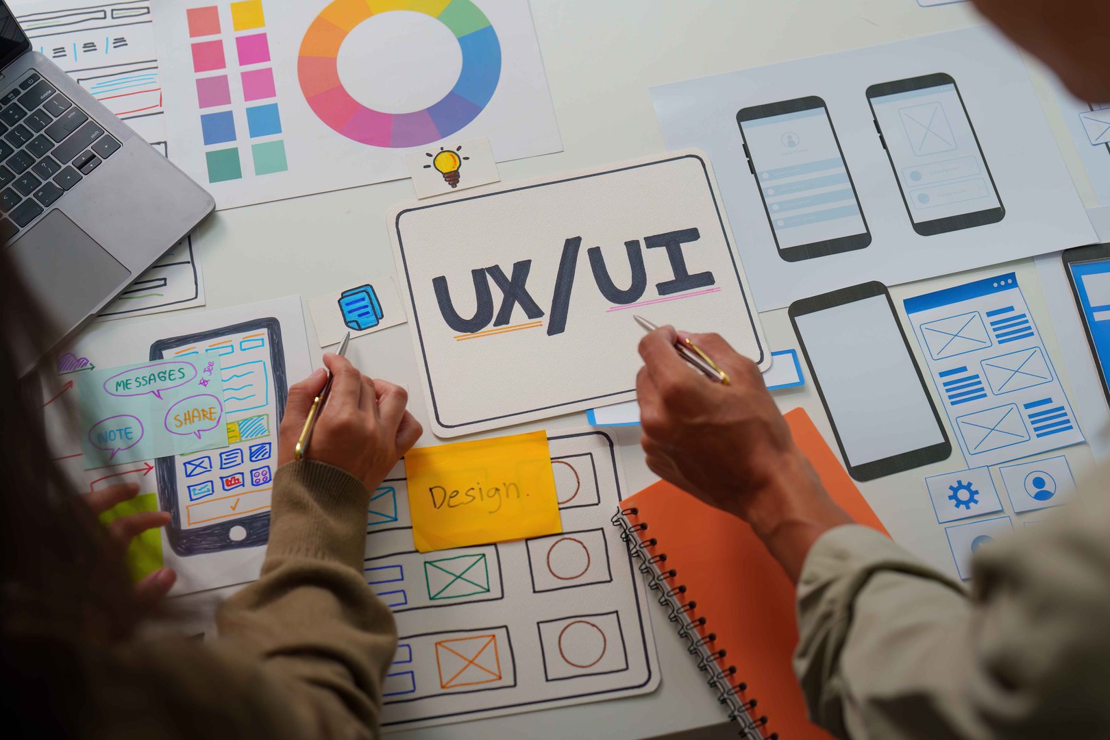 Creative professionals sketching UX UI designs for a mobile application, emphasizing collaboration and innovative ideas.