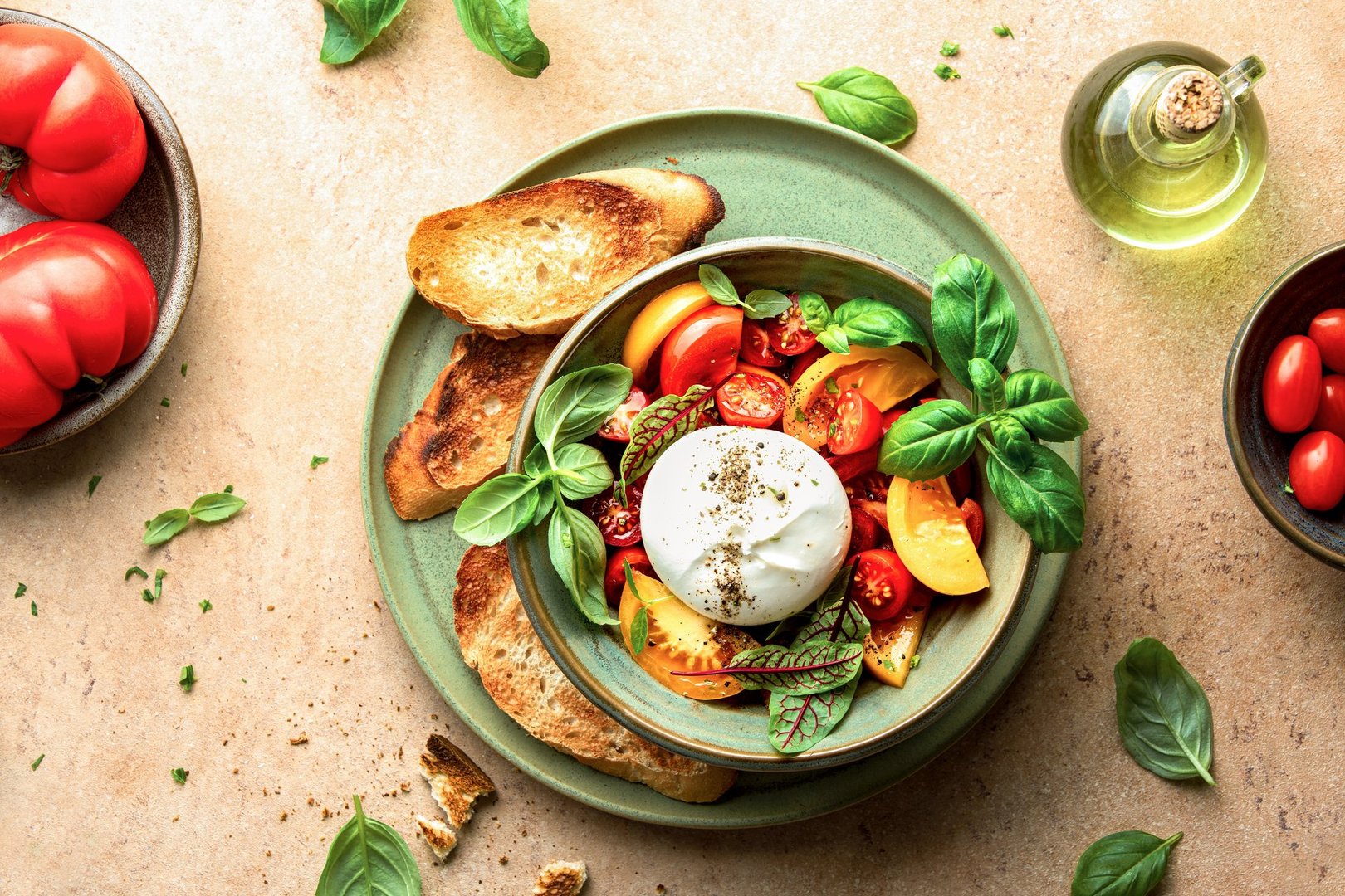 Burrata cheese salad bowl served with bruschetta on a rustic style, overhead view