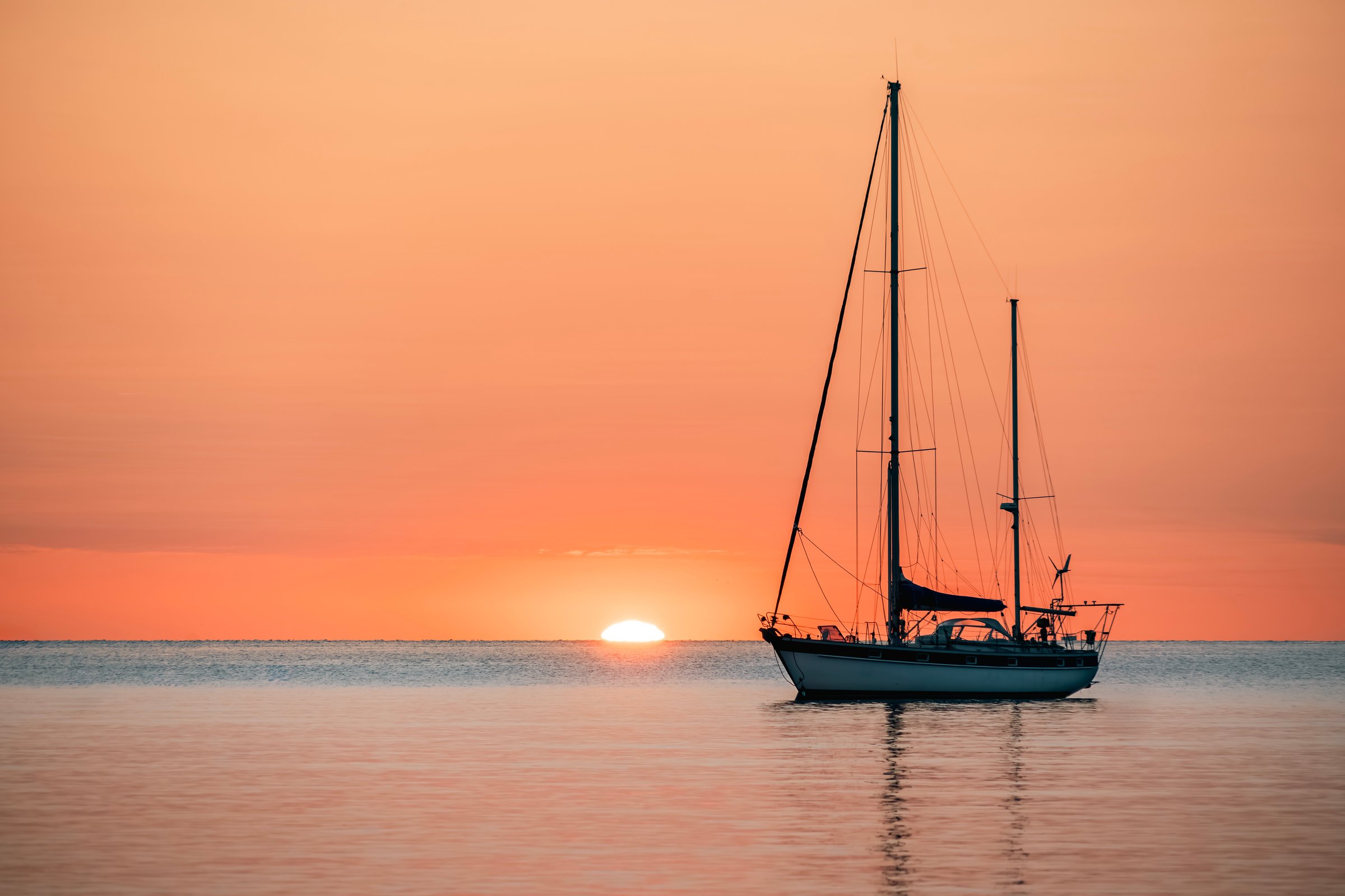 Silhouette Of A Pleasure Boat Moored In The Harbor Of The Coastal And Touristic Village Of Collioure (Cotlliure). France During A Beautiful Sunrise On The Waters Of The Mediterranean Sea. Orange Sky.