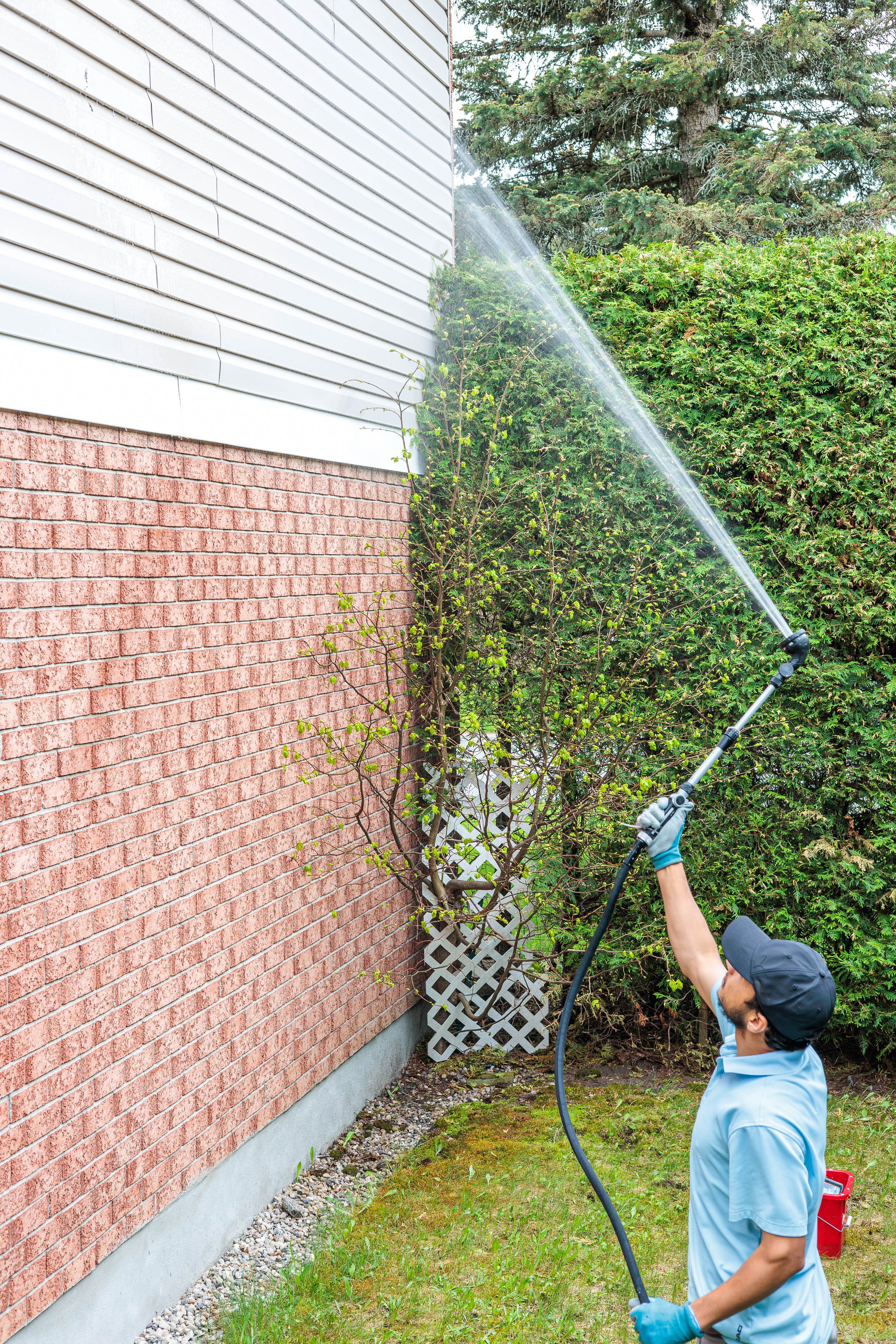 Professional siding cleaning service in Kanata Ottawa - worker power washing house exterior wall