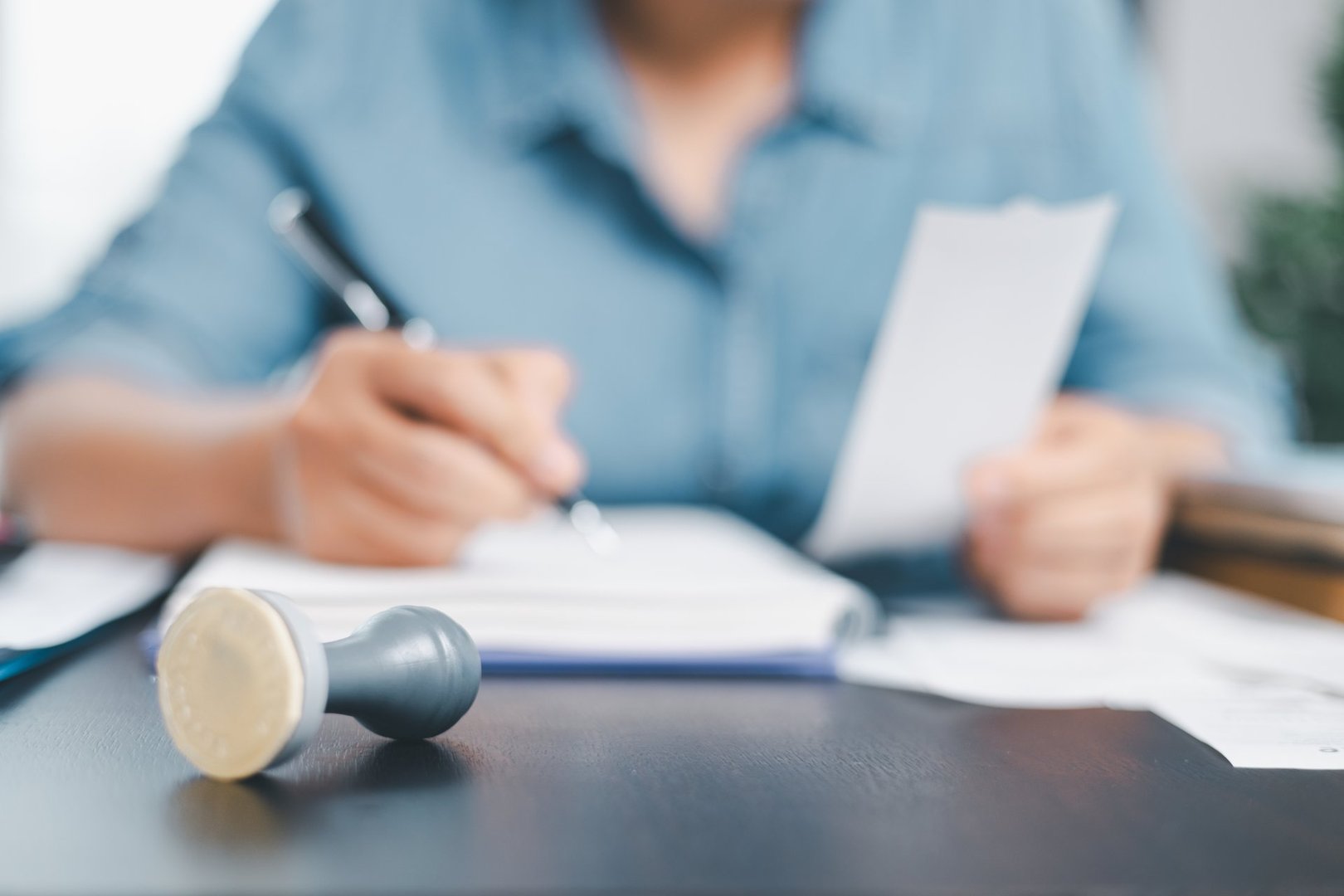 Businessman hands stamp approve on financial business approval document paper. Man hand accepted permit contract agreement. Broker manager sign contract bank guarantee approved stamp application form