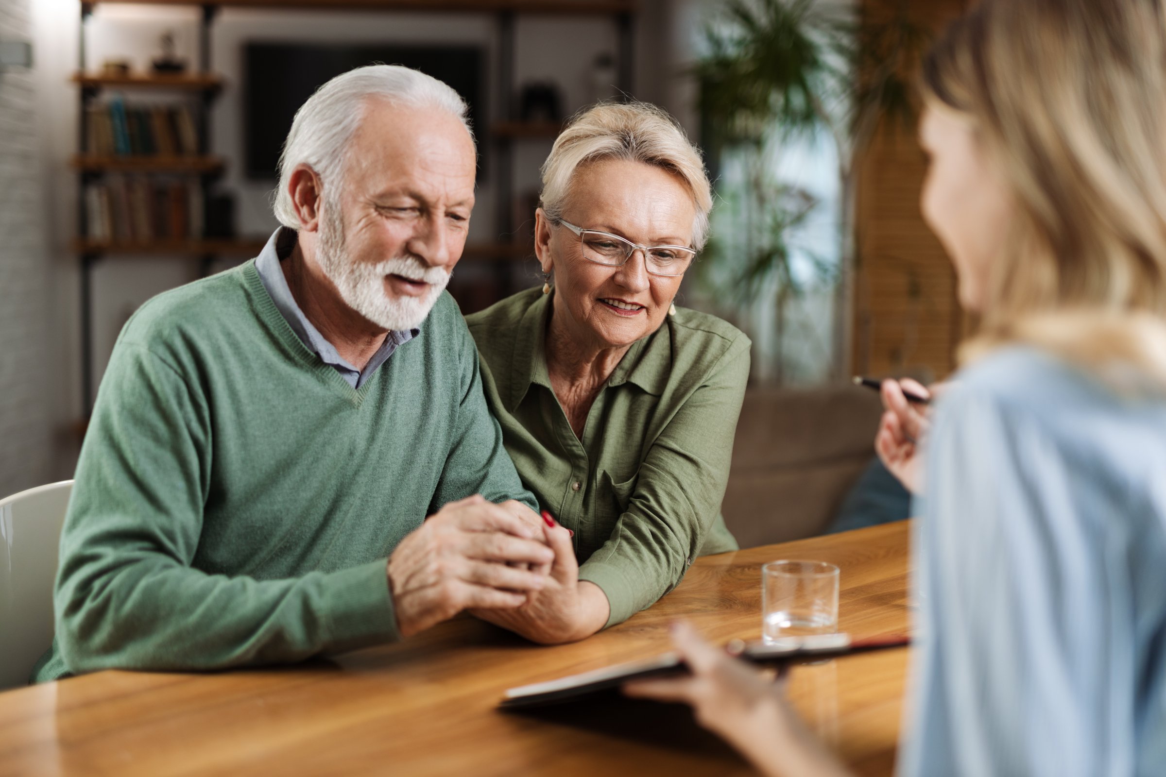 Happy senior couple having a meeting with their insurance agent at home