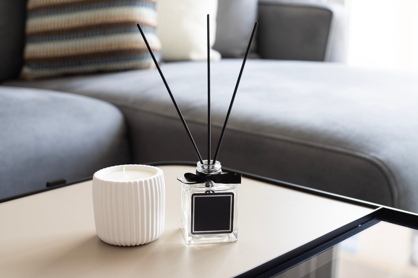 Air reed freshener and candle on table in room
