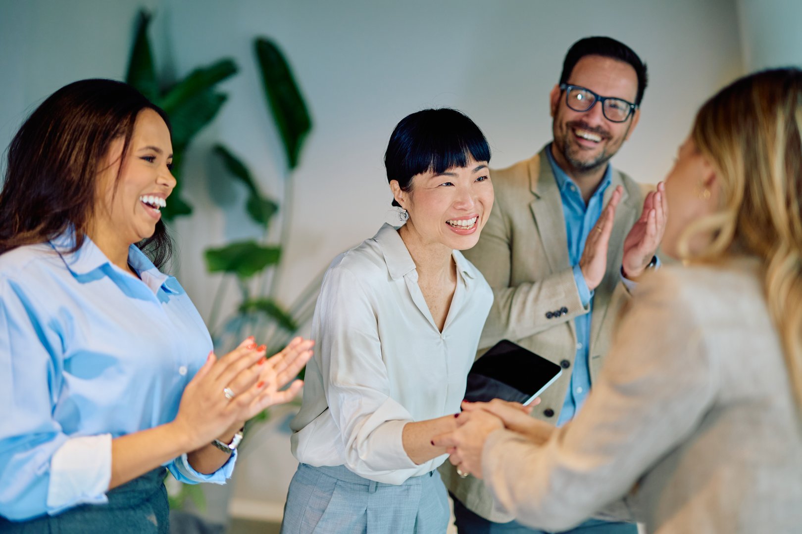 Business team congratulating colleague with handshake