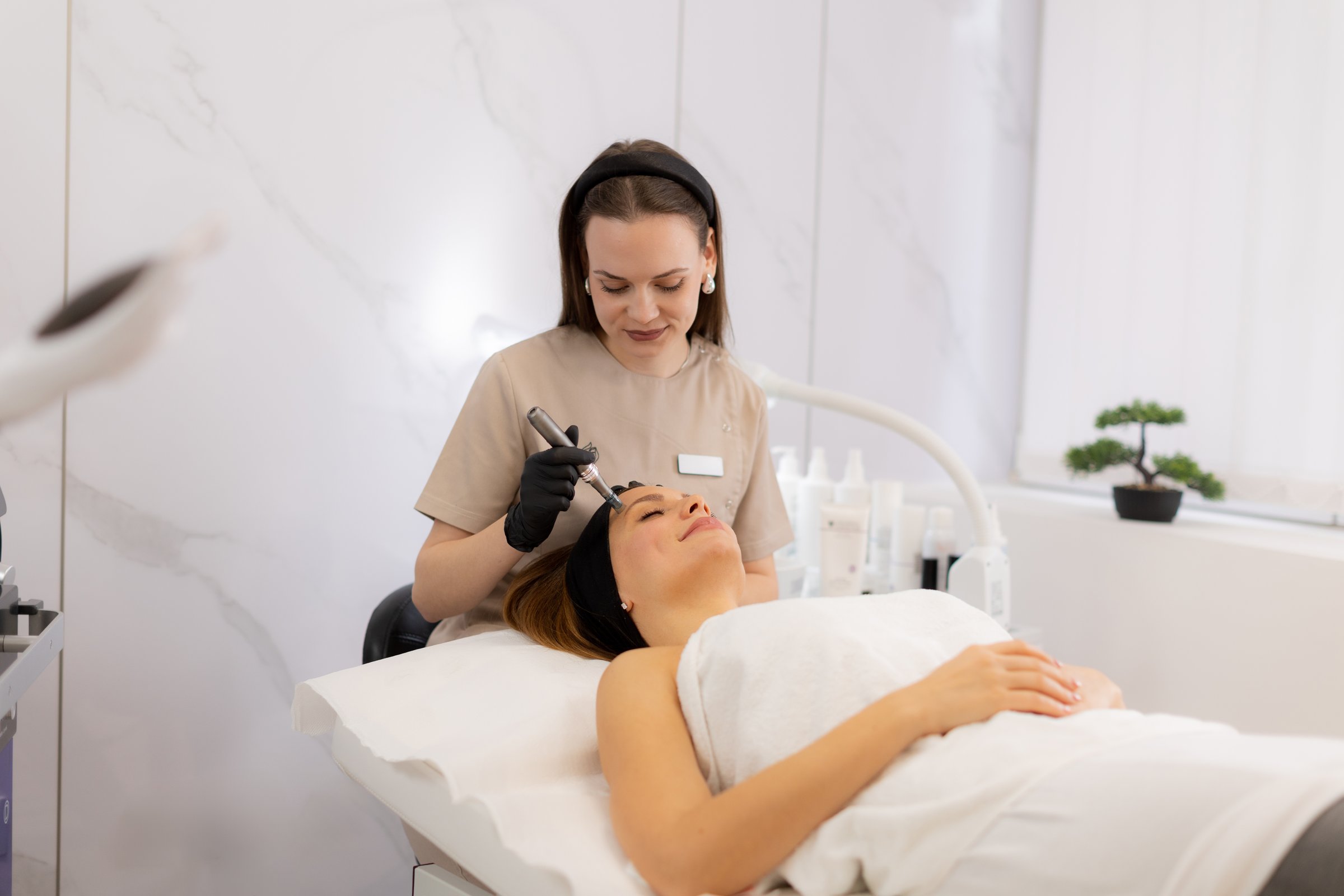 A skilled practitioner uses a microneedling mesotherapy device to revitalize a client's skin. The serene beauty clinic atmosphere complements the transformative treatment experience.