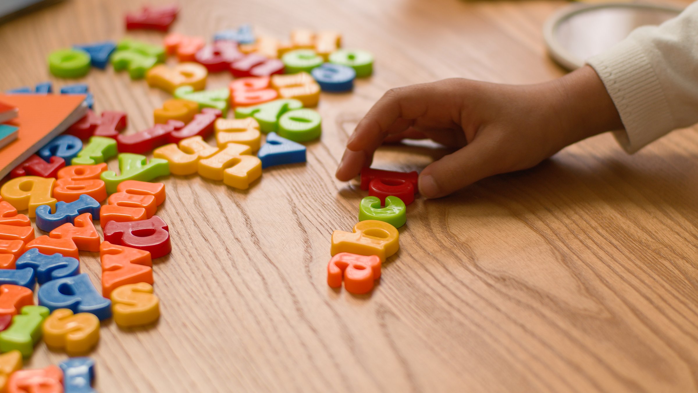 Hands lay out letters alphabet learning study children teach preschool educational kindergarten english language school text lettering development interactive literacy creativity toy colourful toddler.