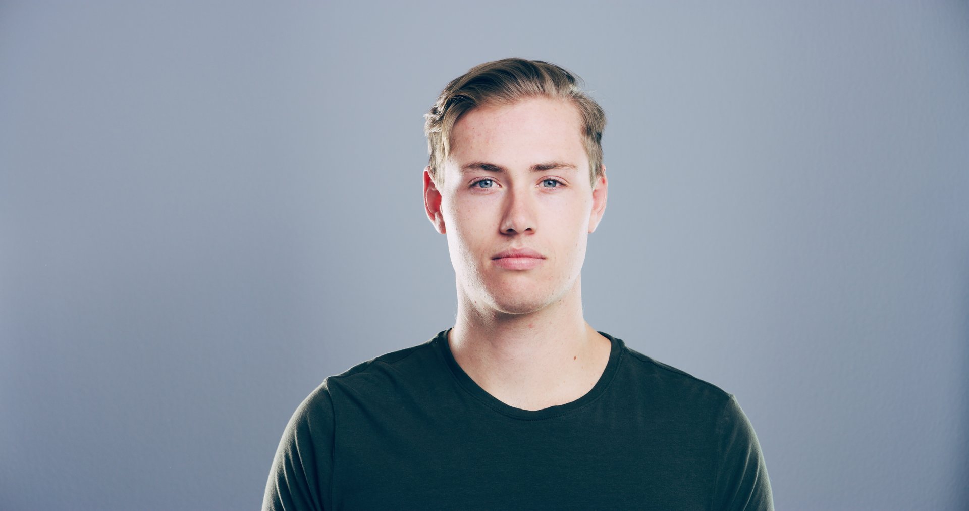 Portrait, space and student with model in studio for development, education or learning. College, scholarship and university with confident man on gray background mockup for academic curriculum