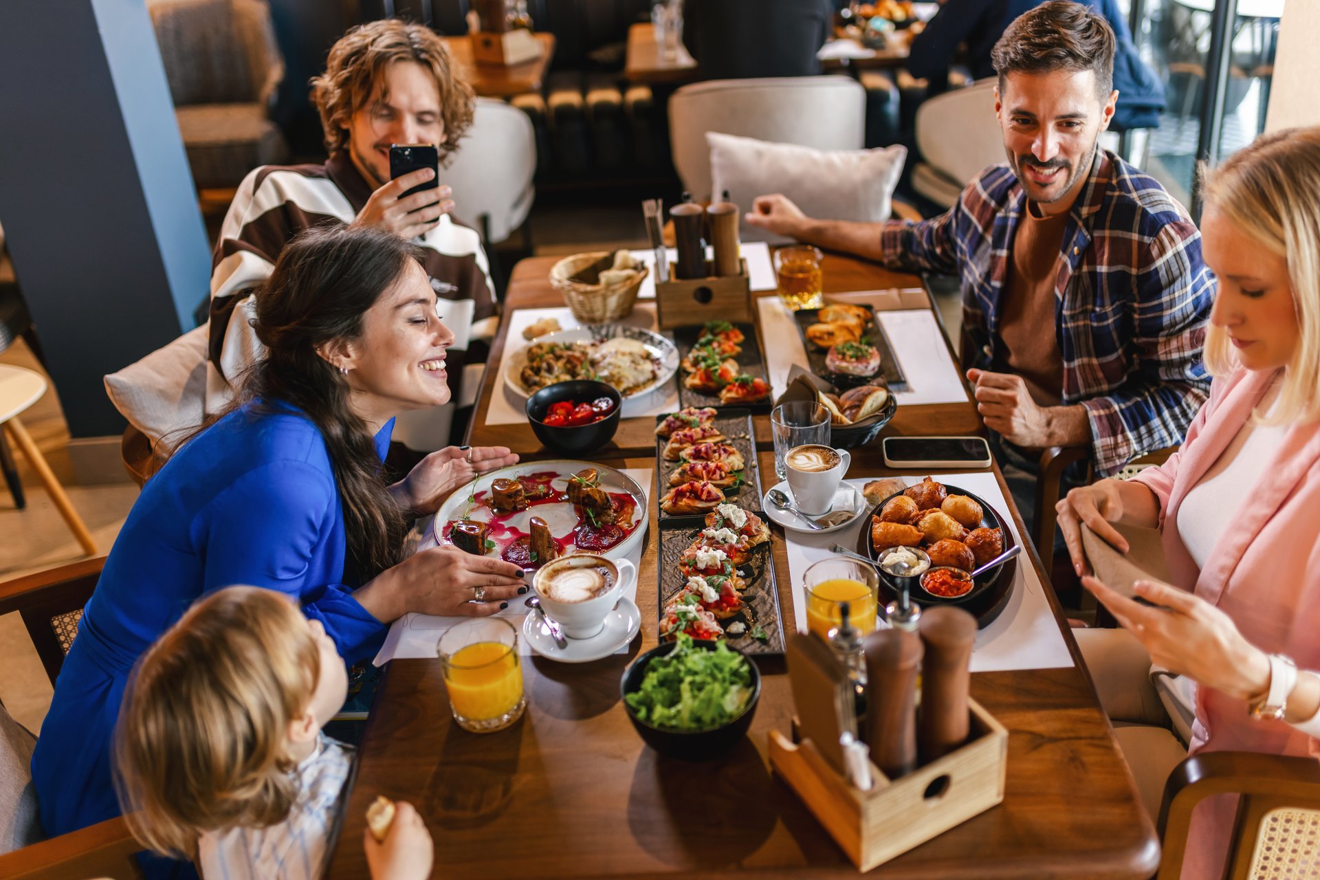 Family gathered in a restaurant to eat delicious food. They eat a variety of tasty foods.