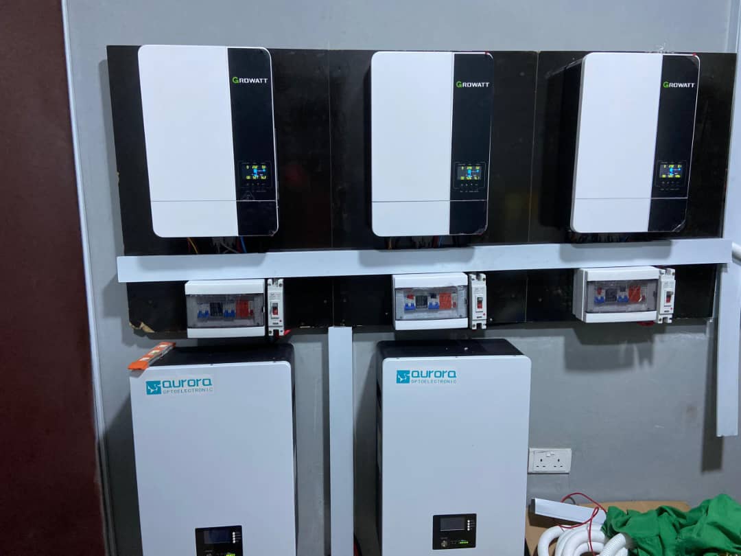 Wall-mounted solar inverters and power storage units with digital displays and wiring. Brand labels are visible.