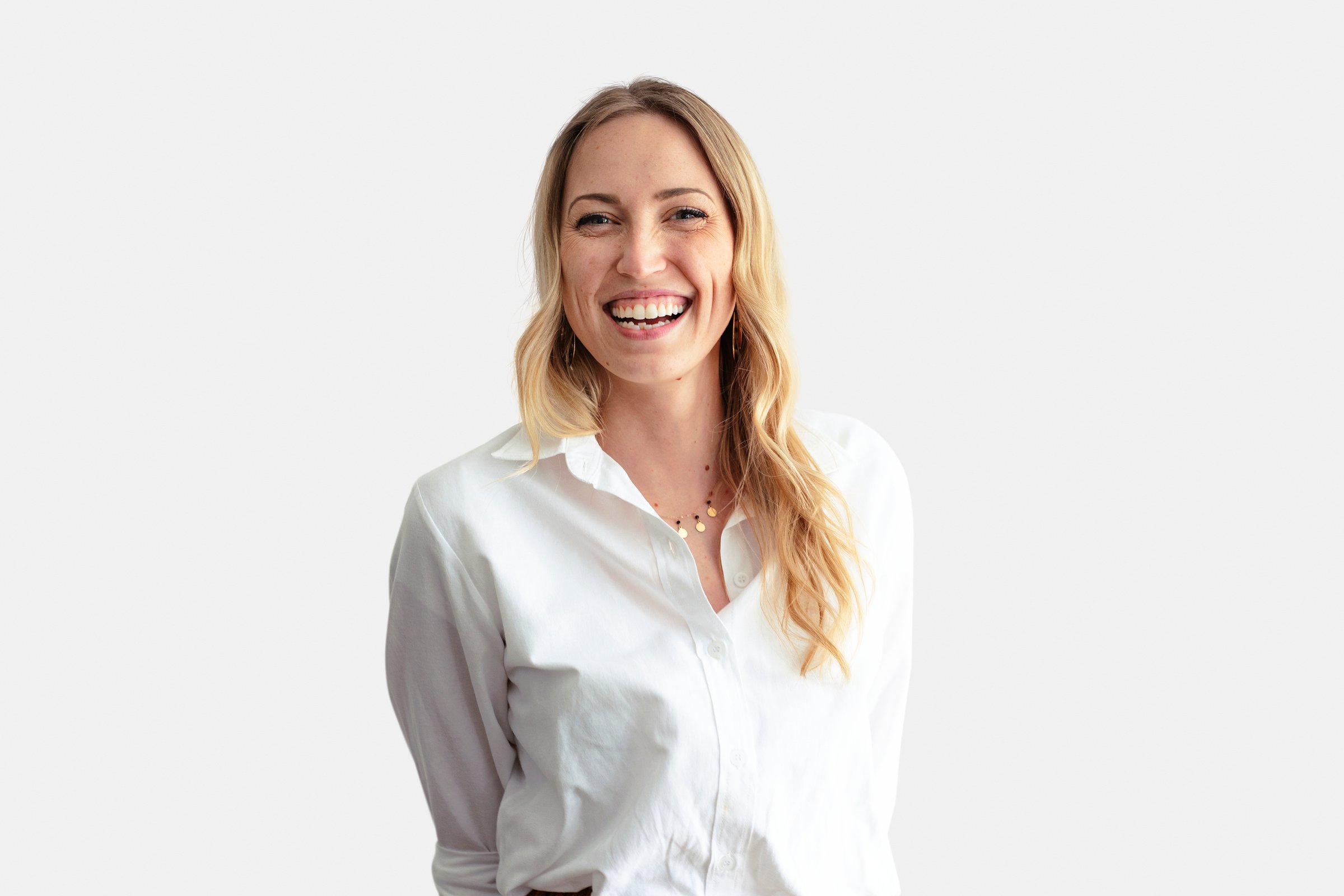 Cheerful woman standing against a white wall