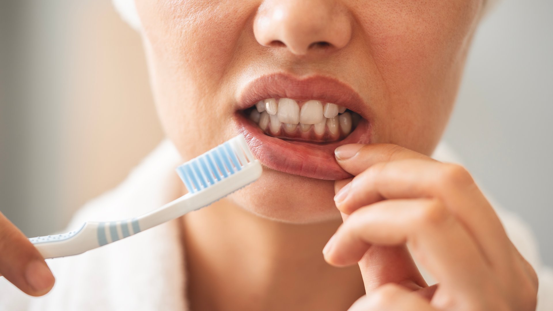 Young woman looking at her red bleeding gums