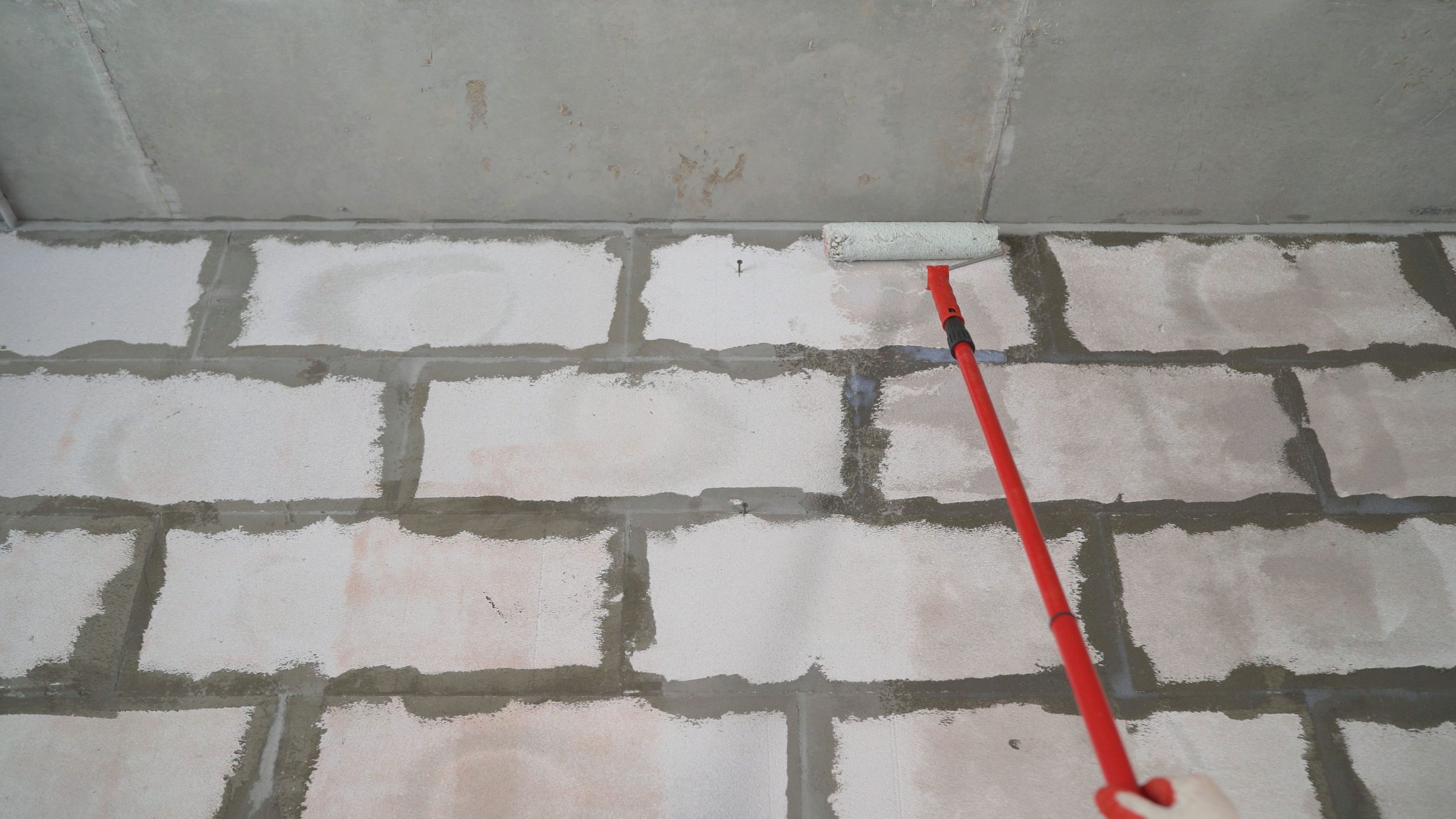 Applying primer to block wall