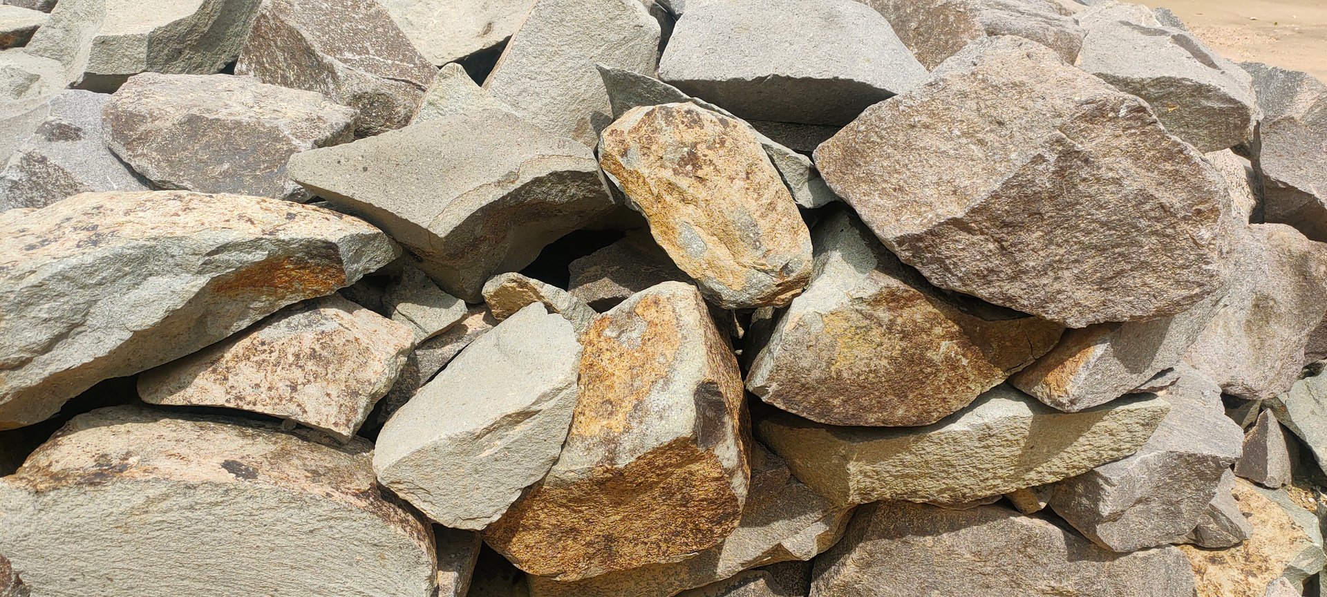 Pile of large rough rocks, varying shades of gray and brown.
