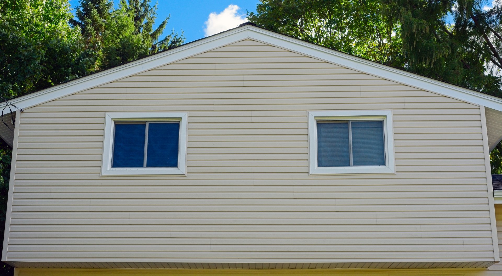 Detail of new vinyl siding on the upper level of a split-level home