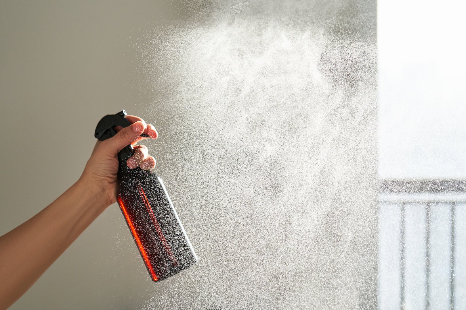 A woman&#039;s hand sprays an air freshener in a room. High quality photo.