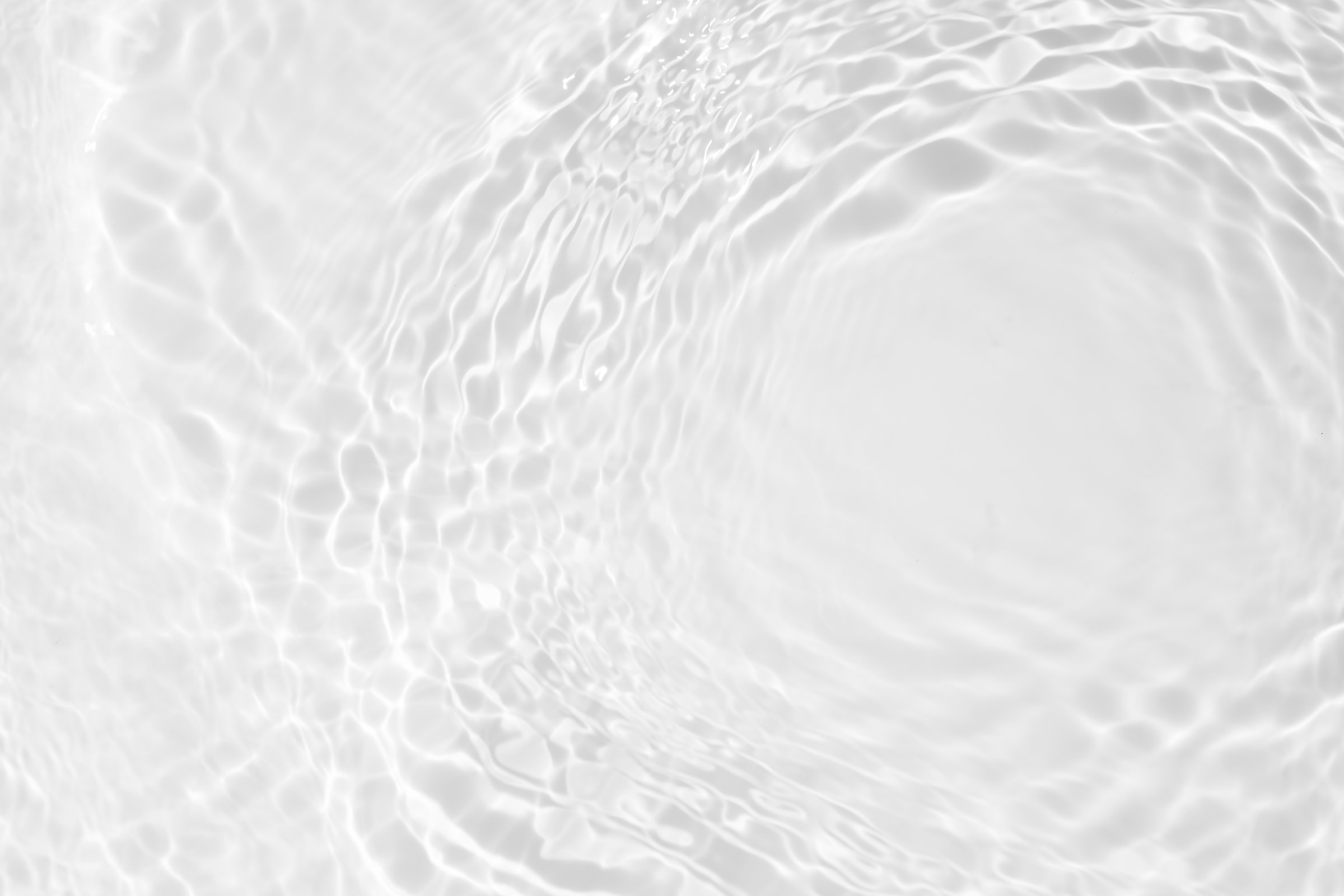 White water with ripples on the surface. Defocus blurred transparent white colored clear calm water surface texture with splashes and bubbles. Water waves with shining pattern texture background.