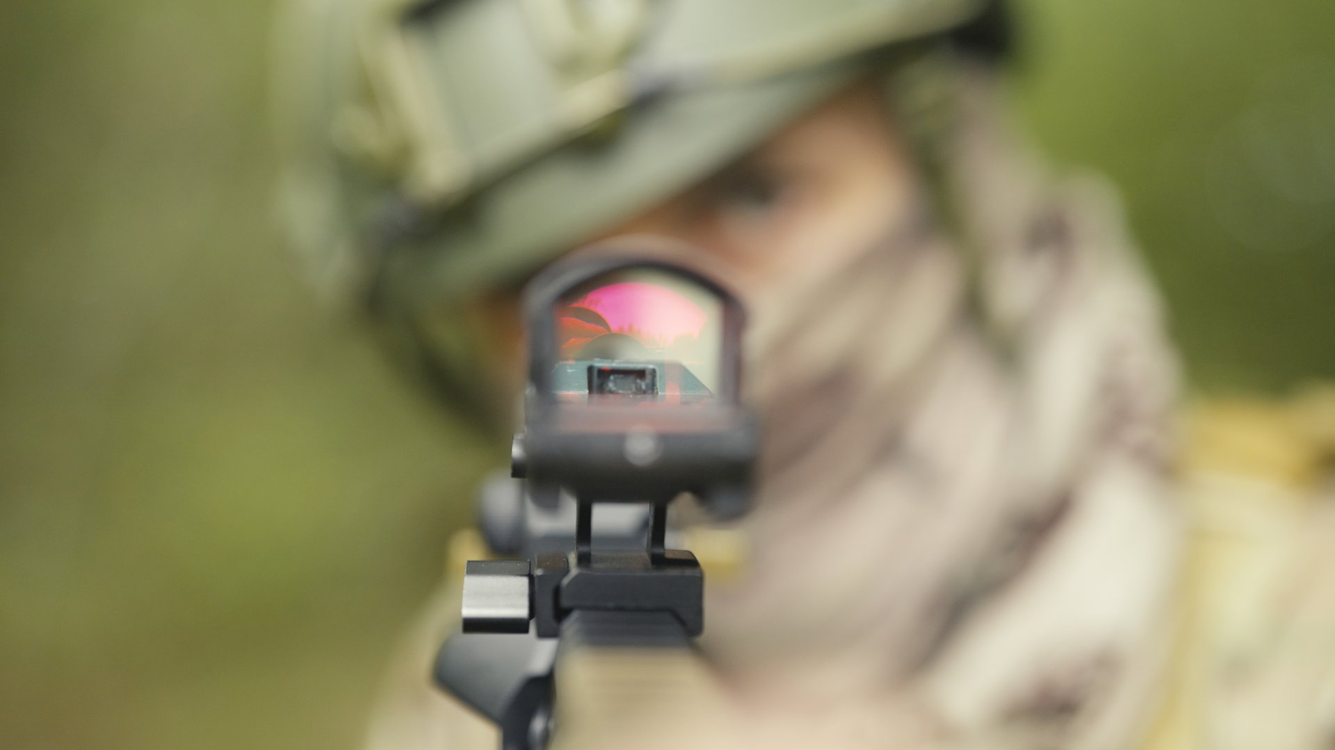 Camouflaged army soldier on a training or a stealth mission in a forest. Carrying a AR15 or M4 carbine and aiming carefully in search of the enemy