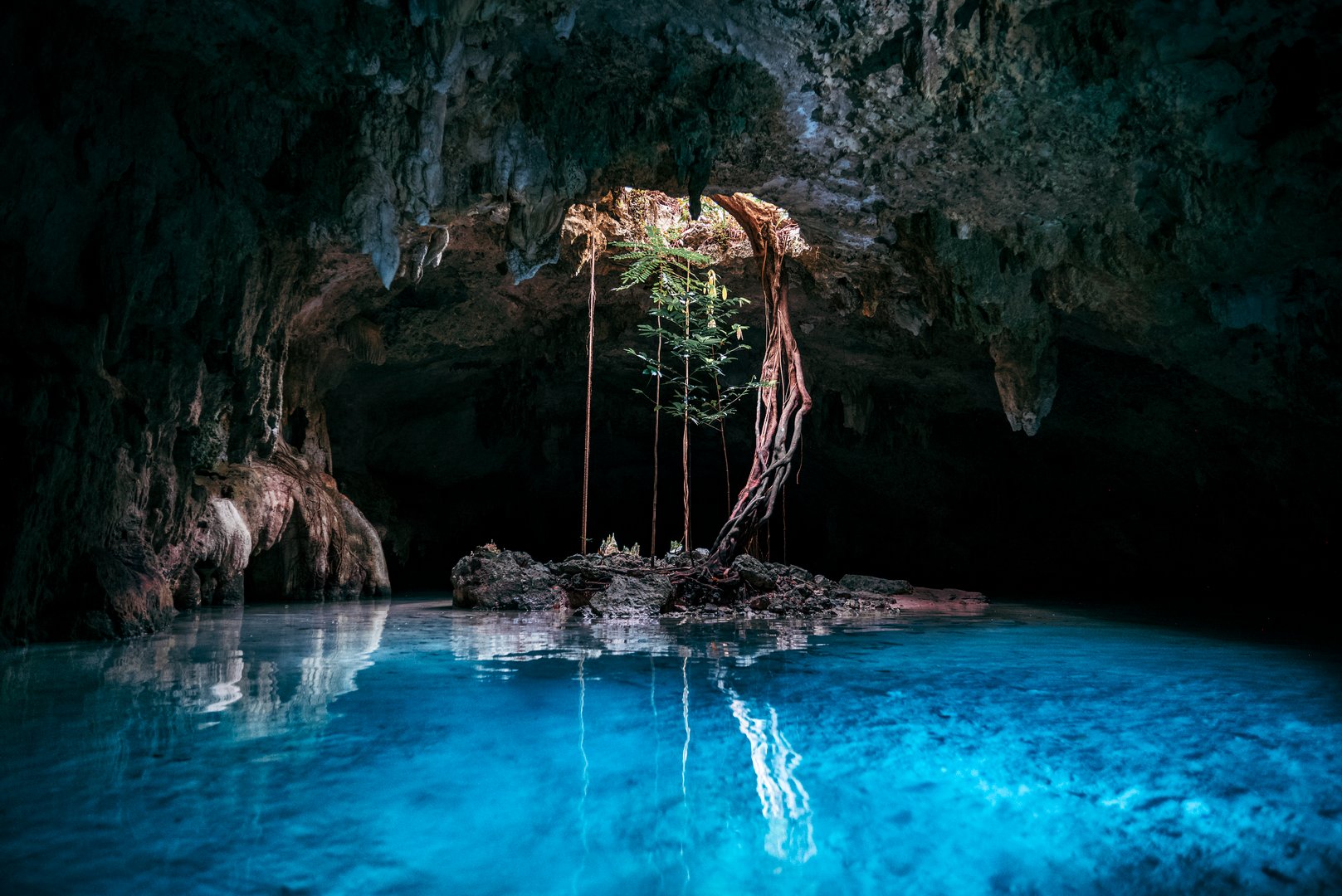 A scenic view of Sac Actun Cenote with blue water in Tulum, Mexico