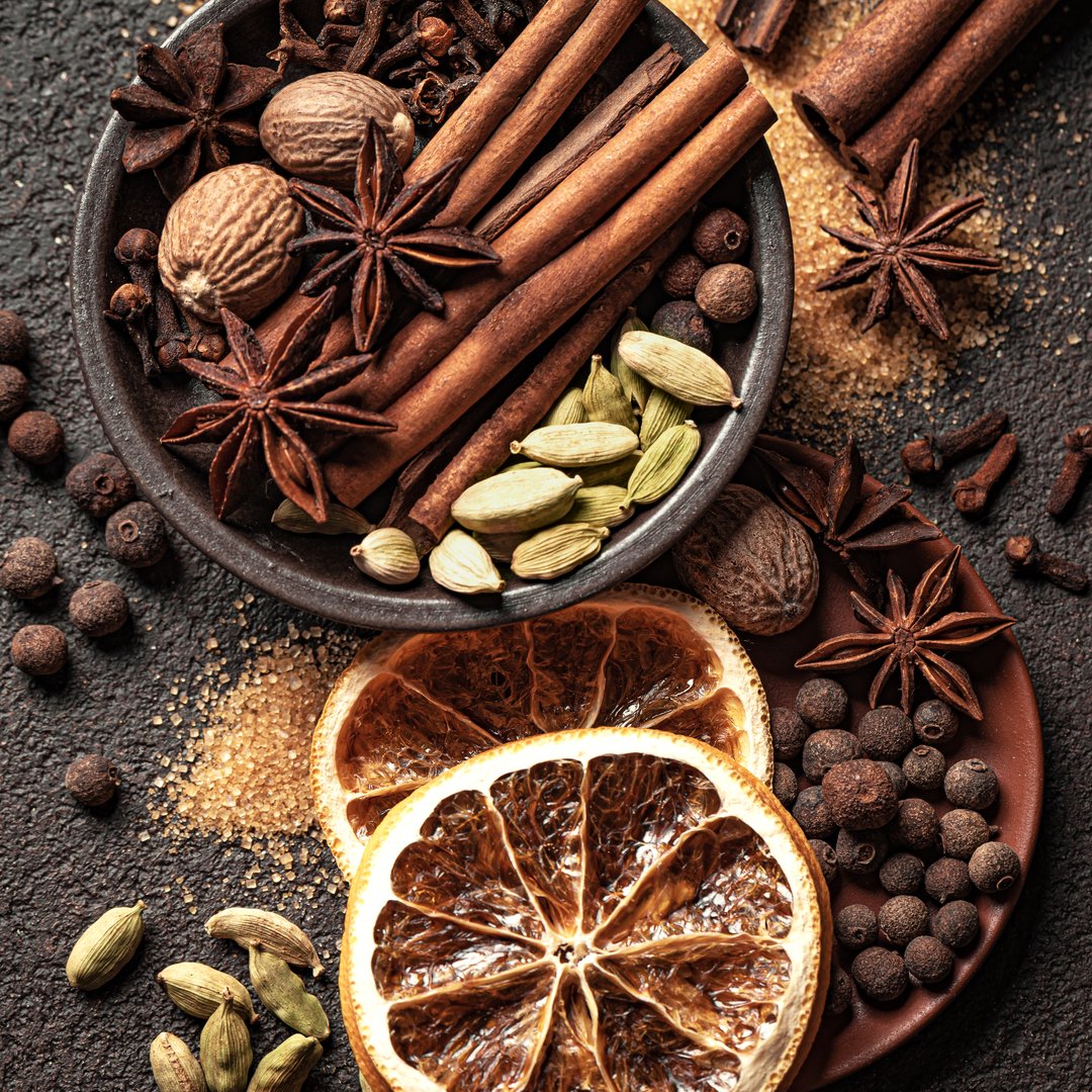 Traditional Christmas aromatic spices and brown sugar, top view. Ingredients for mulled wine. Aesthetic Christmas winter concept.