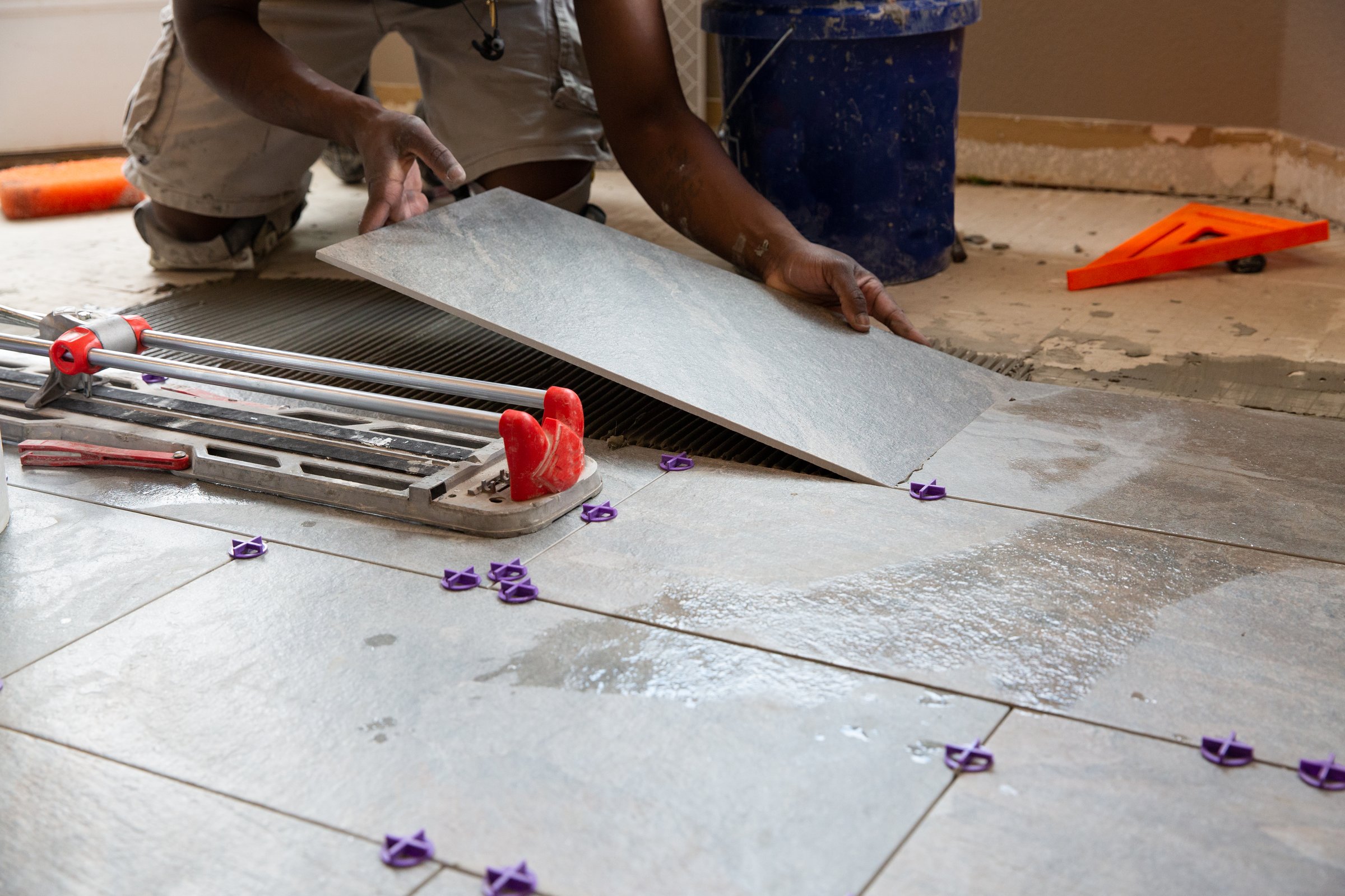 One man installing tile in a kitchen remodel.