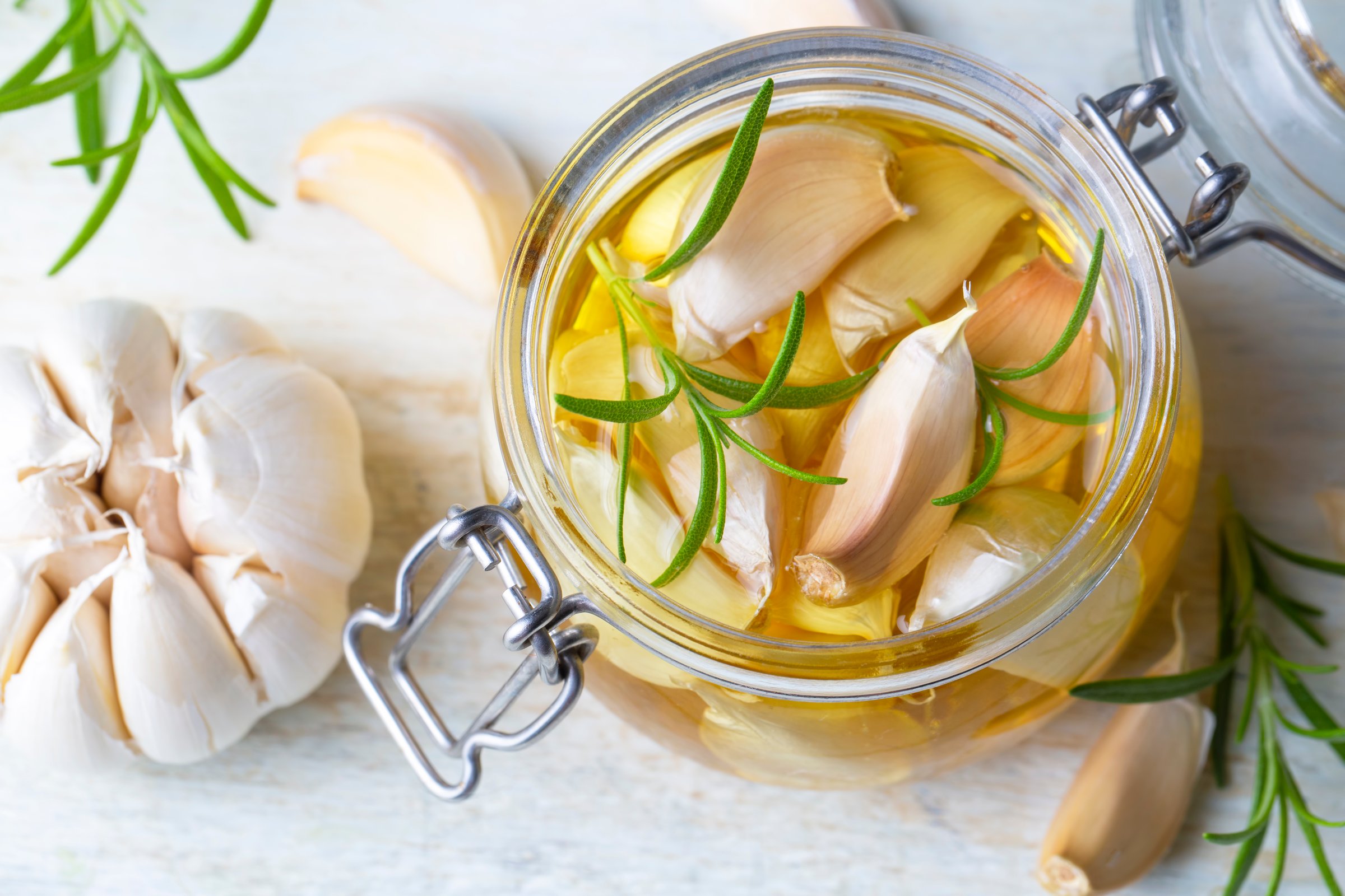 Fresh garlic and garlic oil on the wooden background
