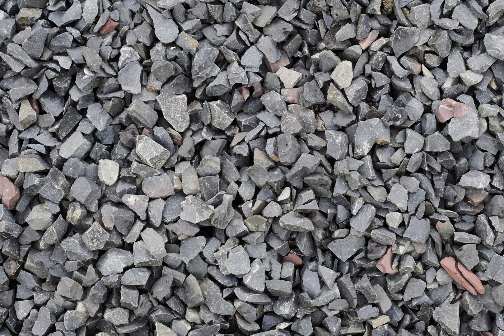Crushed stone close up. Quarry rubble. Small rocks ground. Road building material and granite texture. Construction and road-making material. Garden blue stone gravel. Road base for pathway, driveway