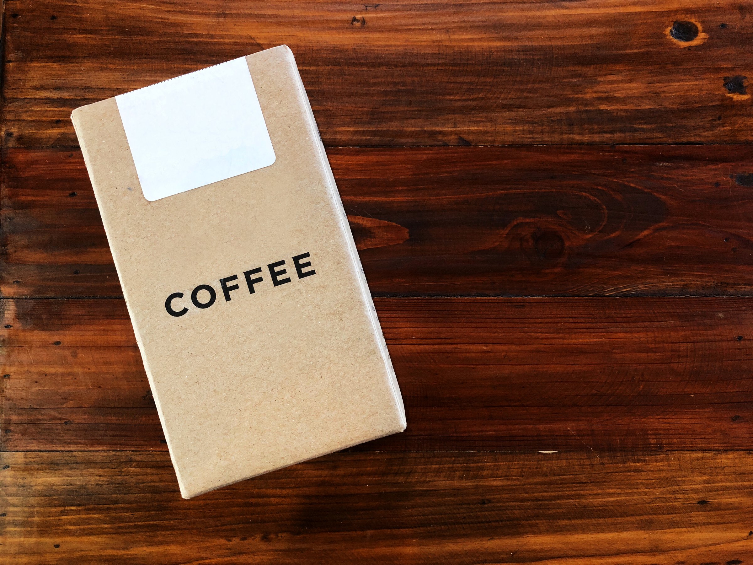 Kraft paper coffee box on the vintage Wooden table,Template idea package for your product . top view and copy space.