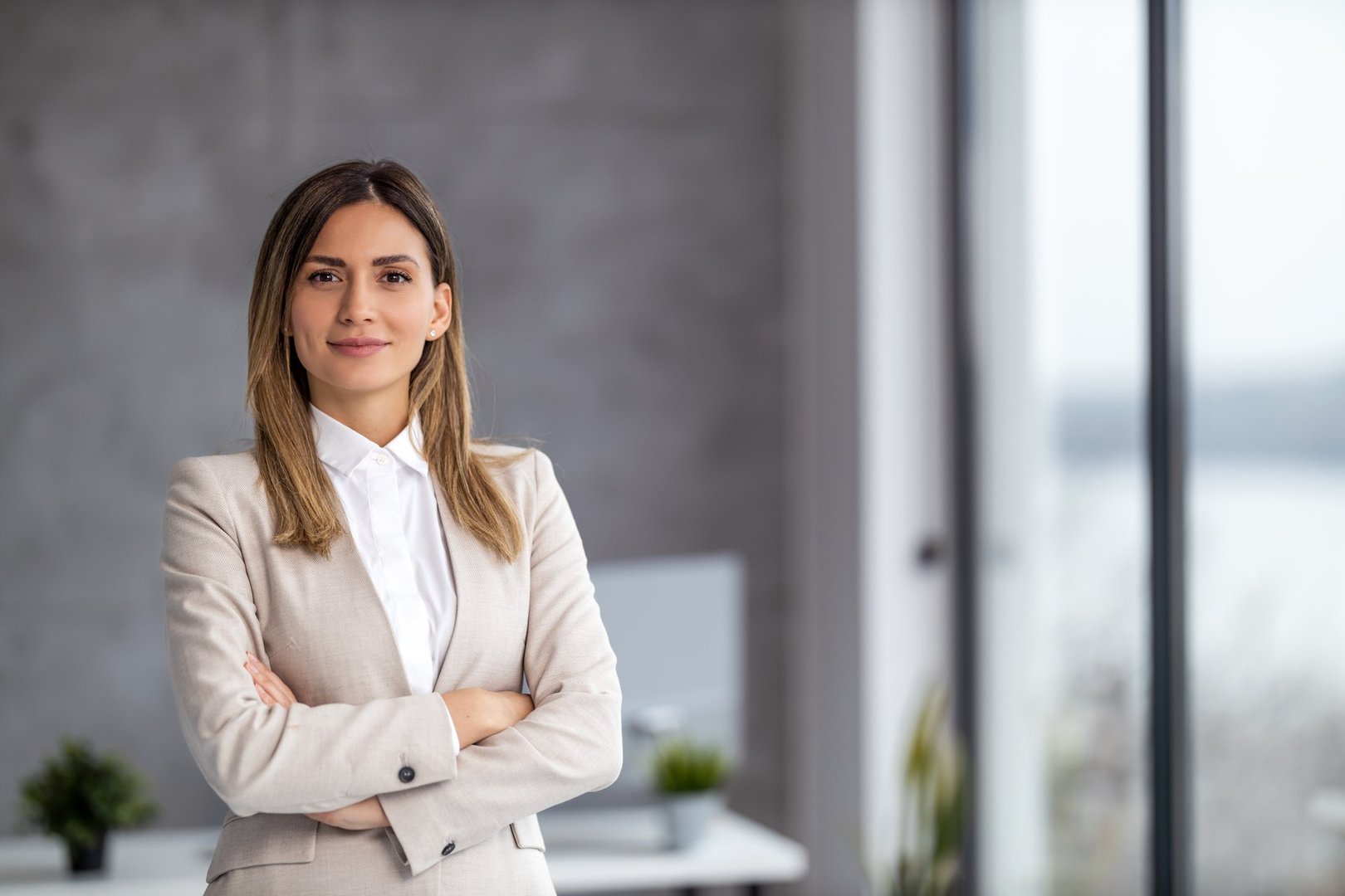 Smiling businesswoman posing in modern office.She is looking at camera.