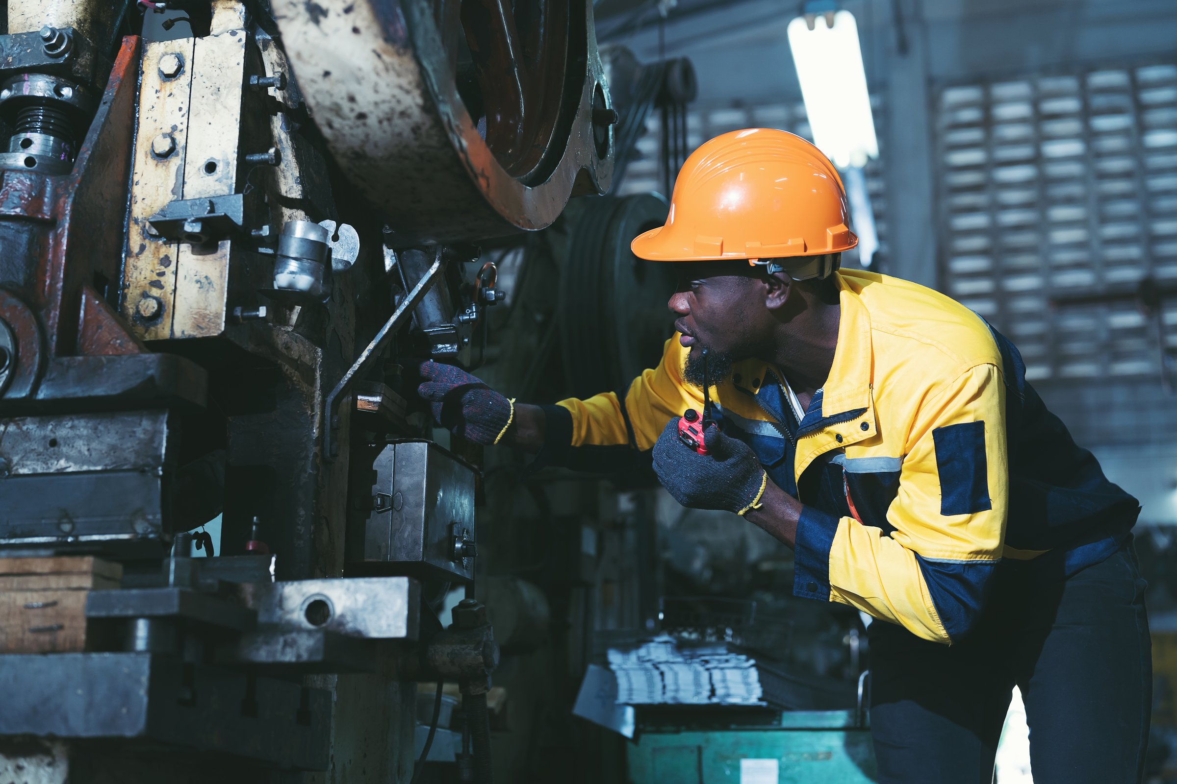 Heavy lathe machine, maintenance, repairing. African American male engineer repairing and maintenance heavy lathe machine in industry factory. Male technician worker checking parts of lathe machine