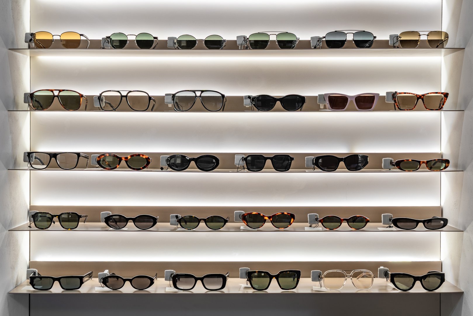 Modern Optical Store Interior with Illuminated Shelves, Sunglasses and Eyeglasses Display